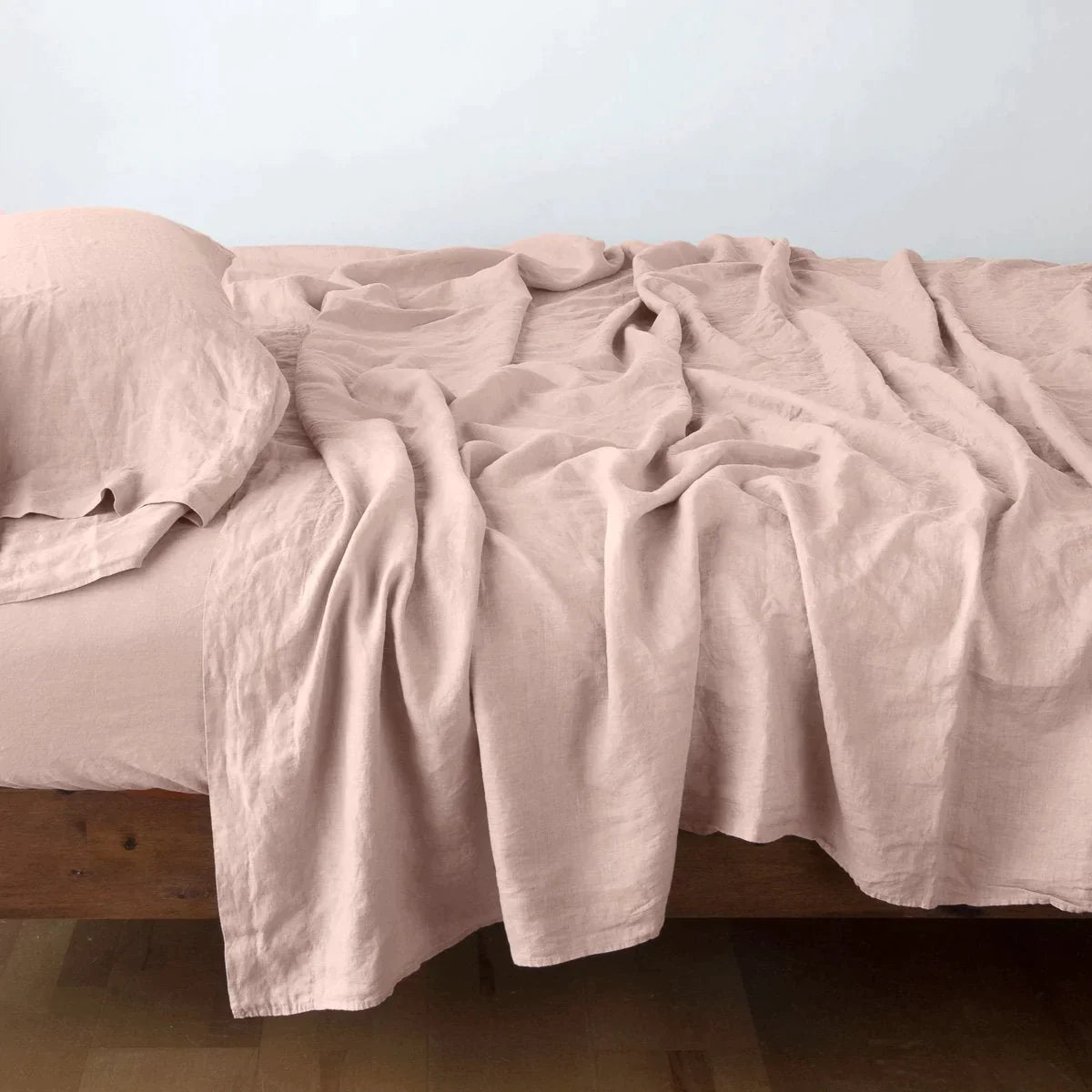Rouge: Rumpled linen sheeting with matching sleeping pillow - side view.