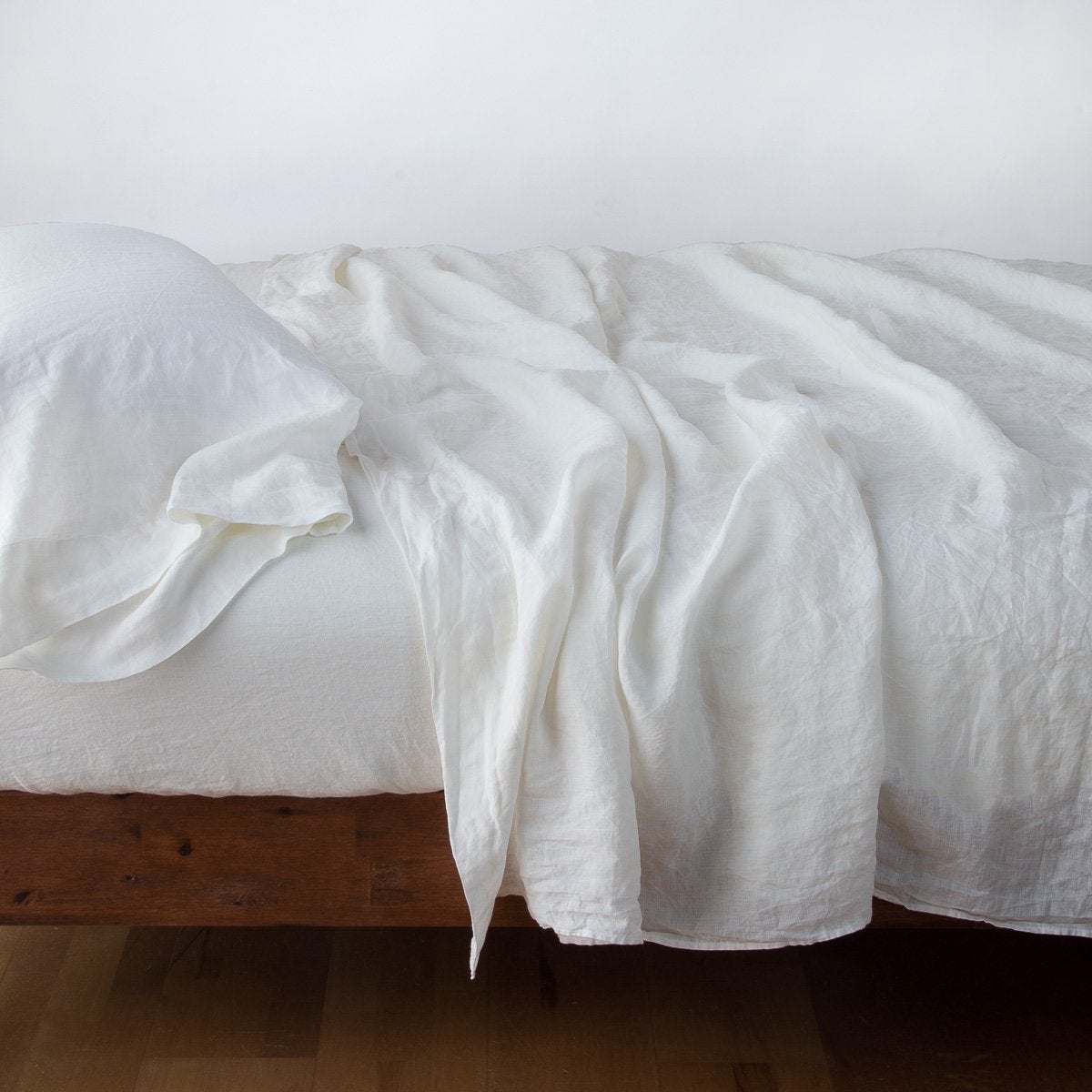 Winter White: sleeping pillow with matching rumpled sheeting - side view.