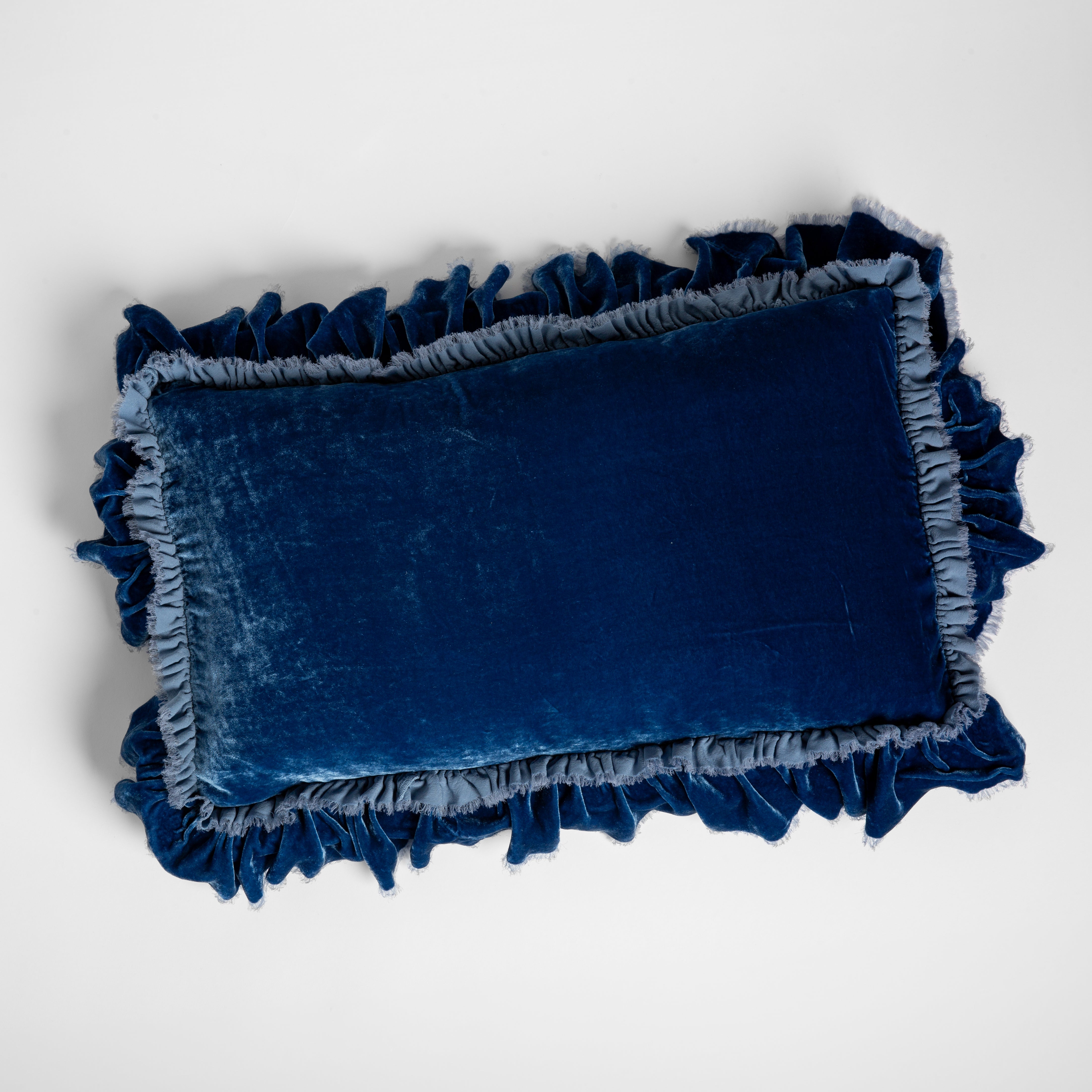 Tahoe Blue: overhead shot of a 15x24 silk velvet pillow with a raw edge ruffle detail. 