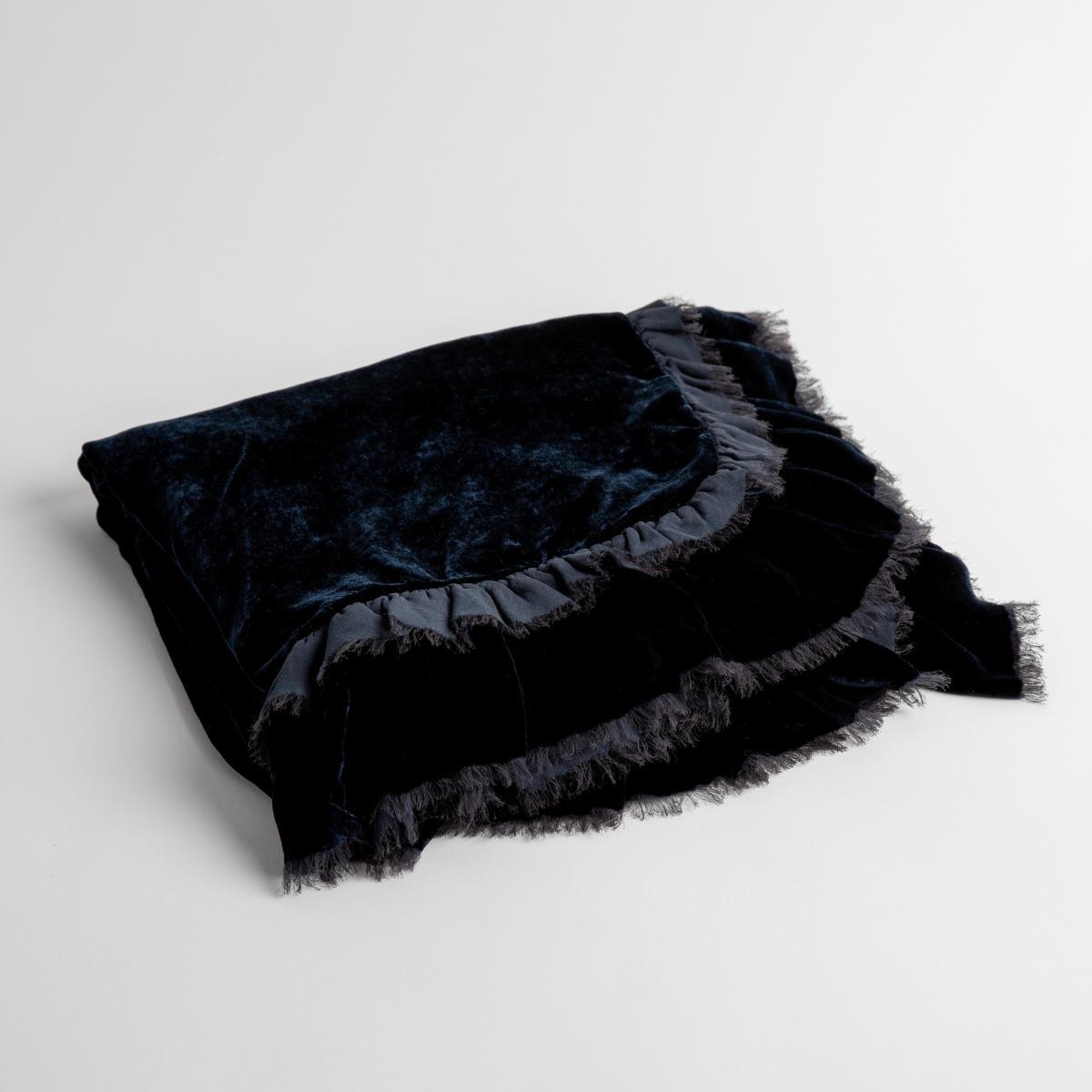 Midnight:  an overhead shot of a folded silk velvet baby blanket with a raw-edged eyelash ruffle detail.