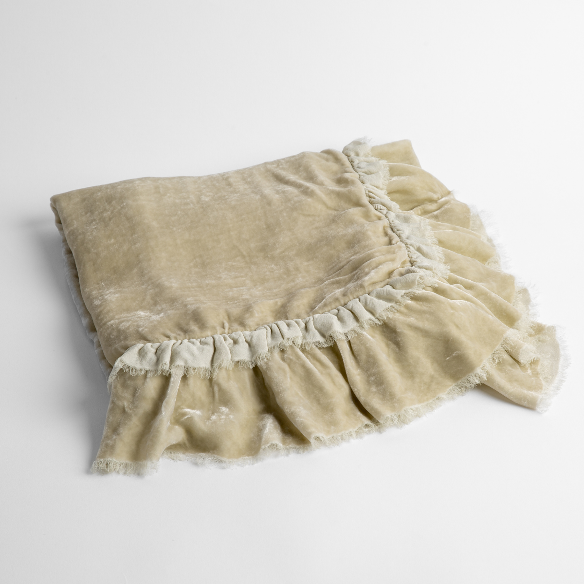 Parchment:  an overhead shot of a folded silk velvet baby blanket with a raw-edged eyelash ruffle detail.