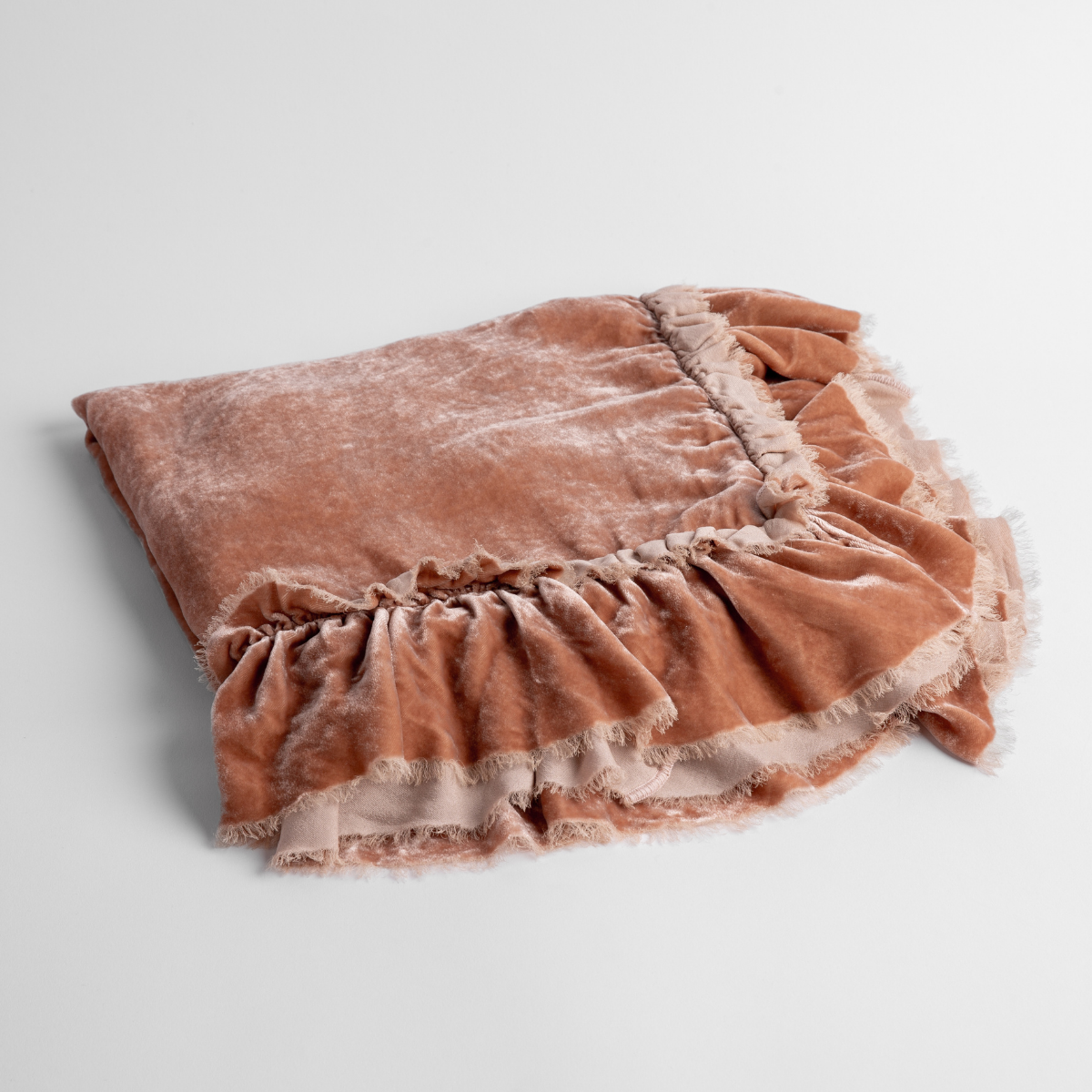Rouge:  an overhead shot of a folded silk velvet baby blanket with a raw-edged eyelash ruffle detail.