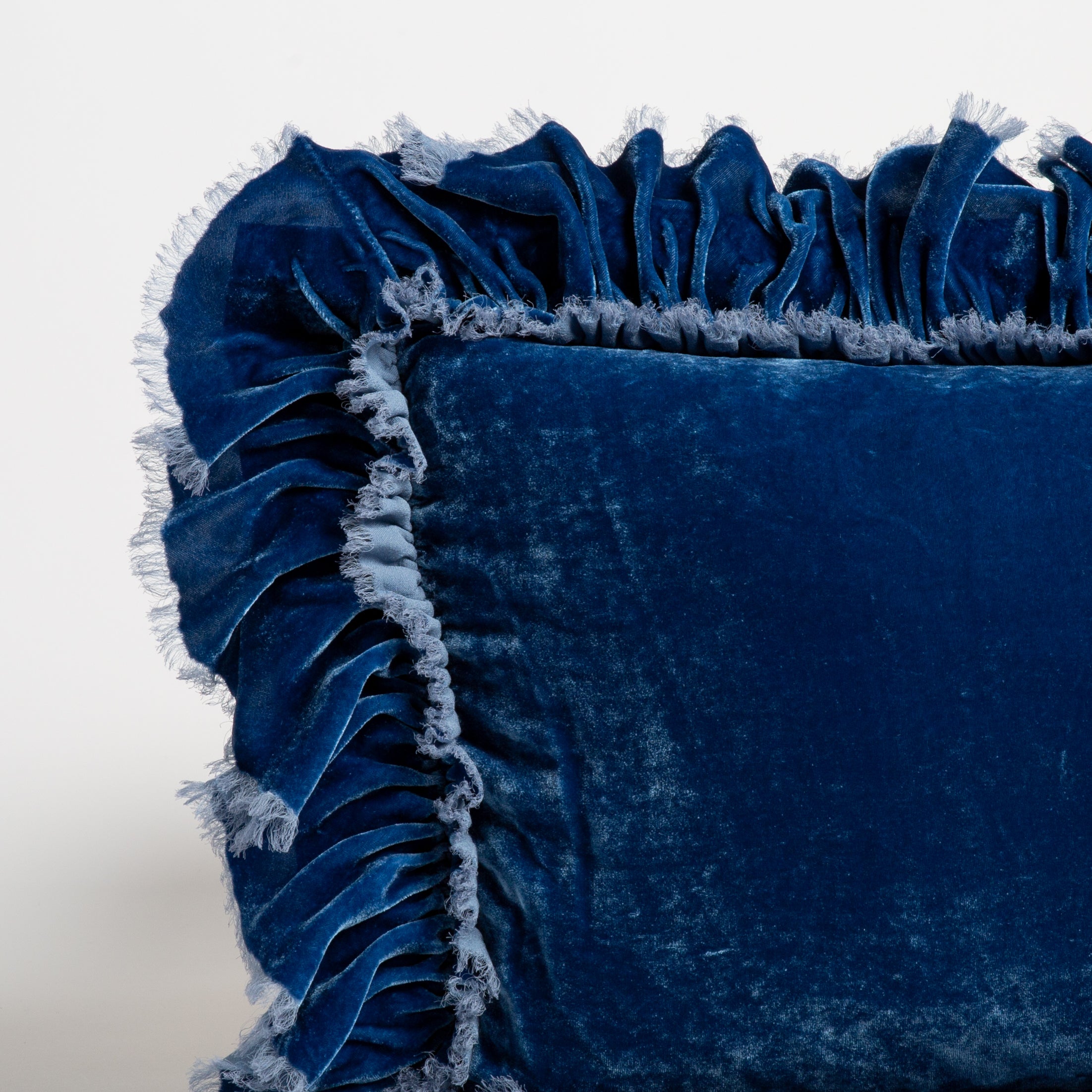 Tahoe Blue: close up of the corner of a silk velvet pillow with raw edged ruffle detail. 