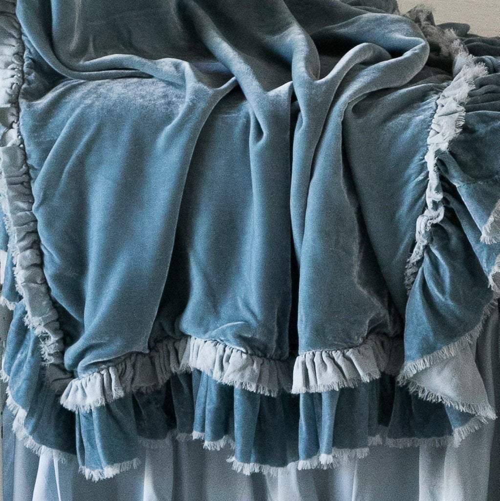 : Close-up of rumpled Loulah baby blanket in cloud, showcasing the raw edge ruffle trim.