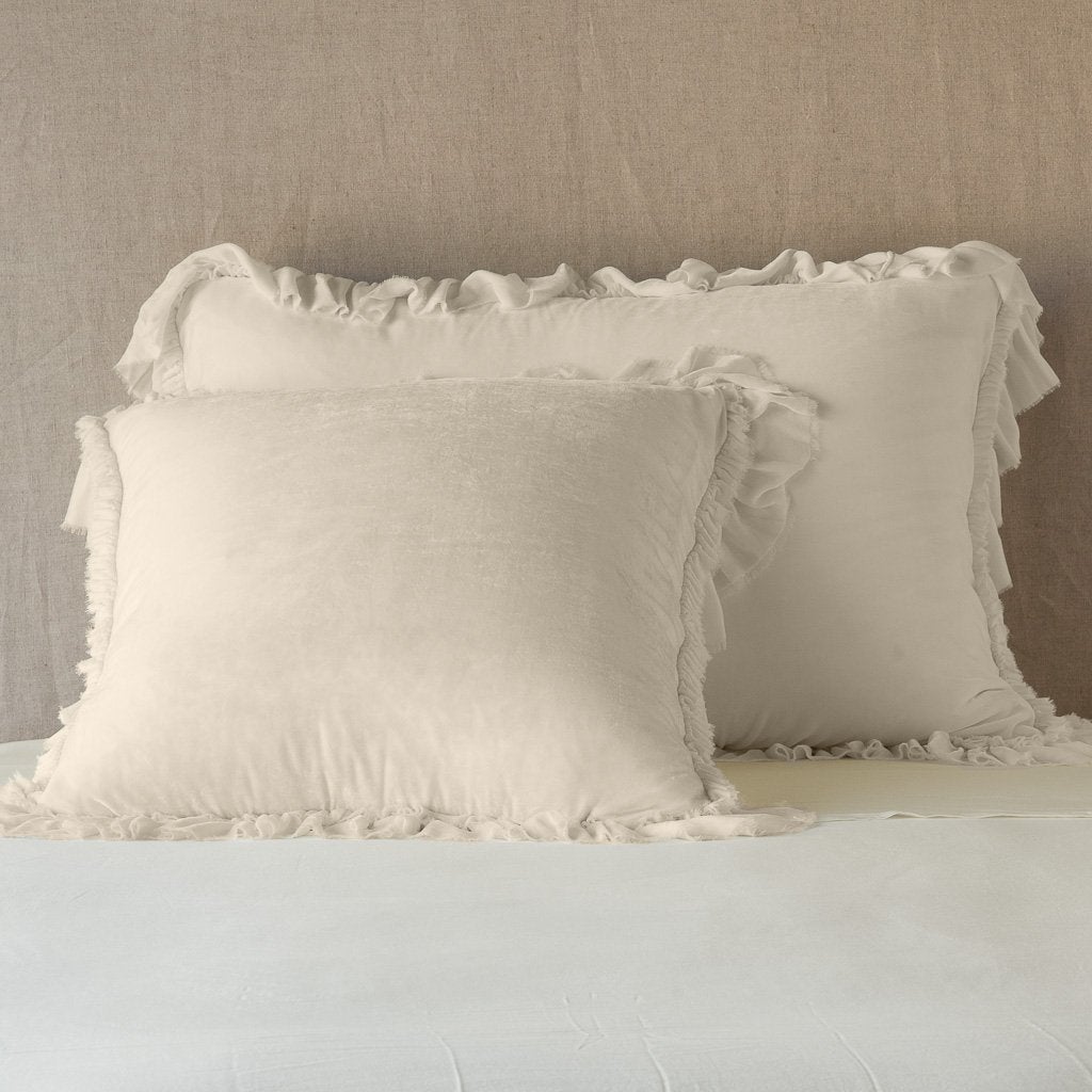 Parchment: shams leaning upright on white sheets against a neutral headboard.