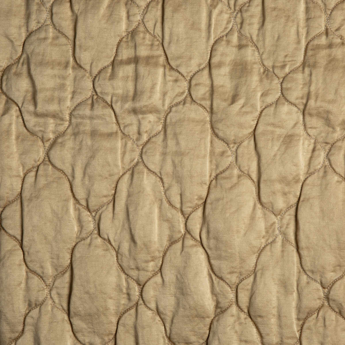 Honeycomb: A close up of quilted charmeuse fabric in honeycomb, a warm golden tone.