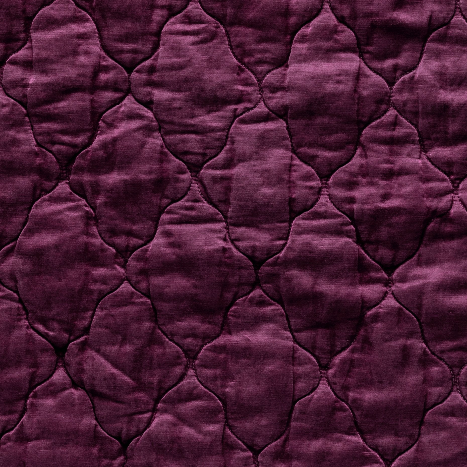 Fig: Close-up of Luna silk charmeuse quilting in fig, a richly saturated purple-garnet. 