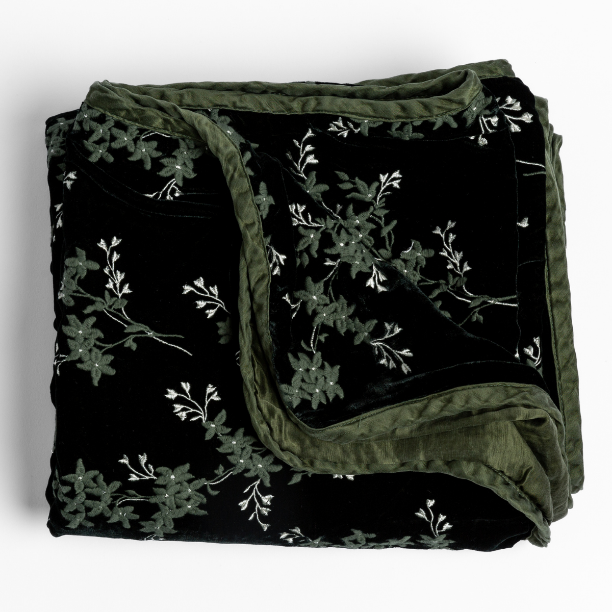 Folded embroidered silk velvet blanket with charmeuse trim shot from overhead to show floral pattern