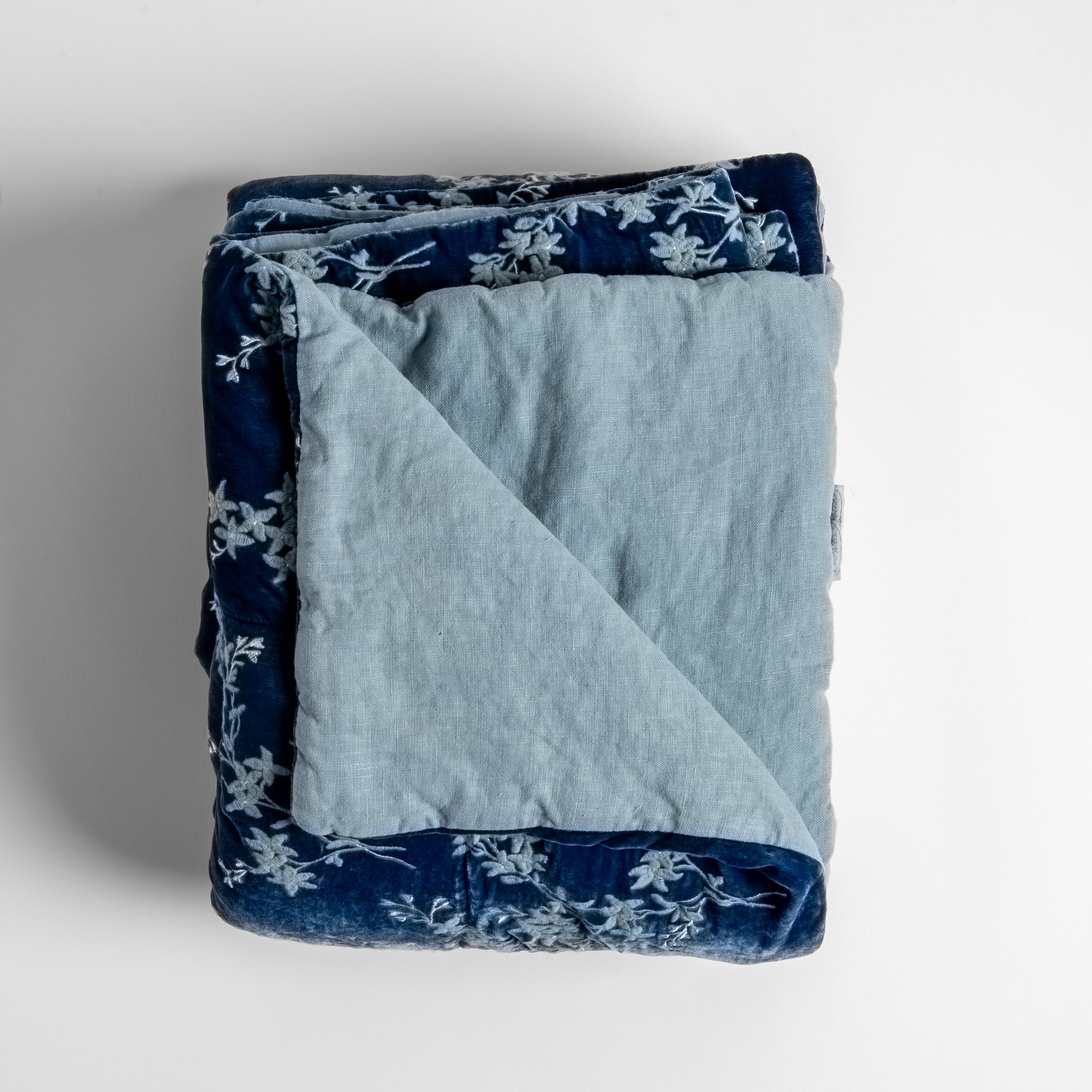 Tahoe Blue: Close up of folded blanket, with a corner turned back to showcase the linen back - overhead view.