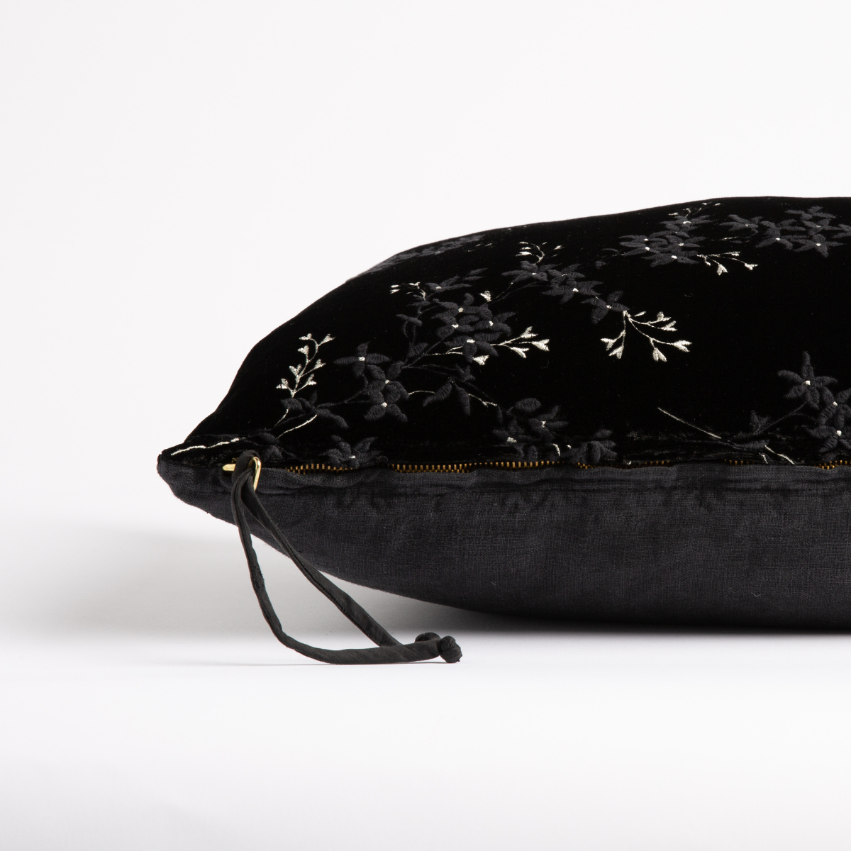 Corvino: Close-up side vew featuring brass zipper with charmeuse pull, and linen back.