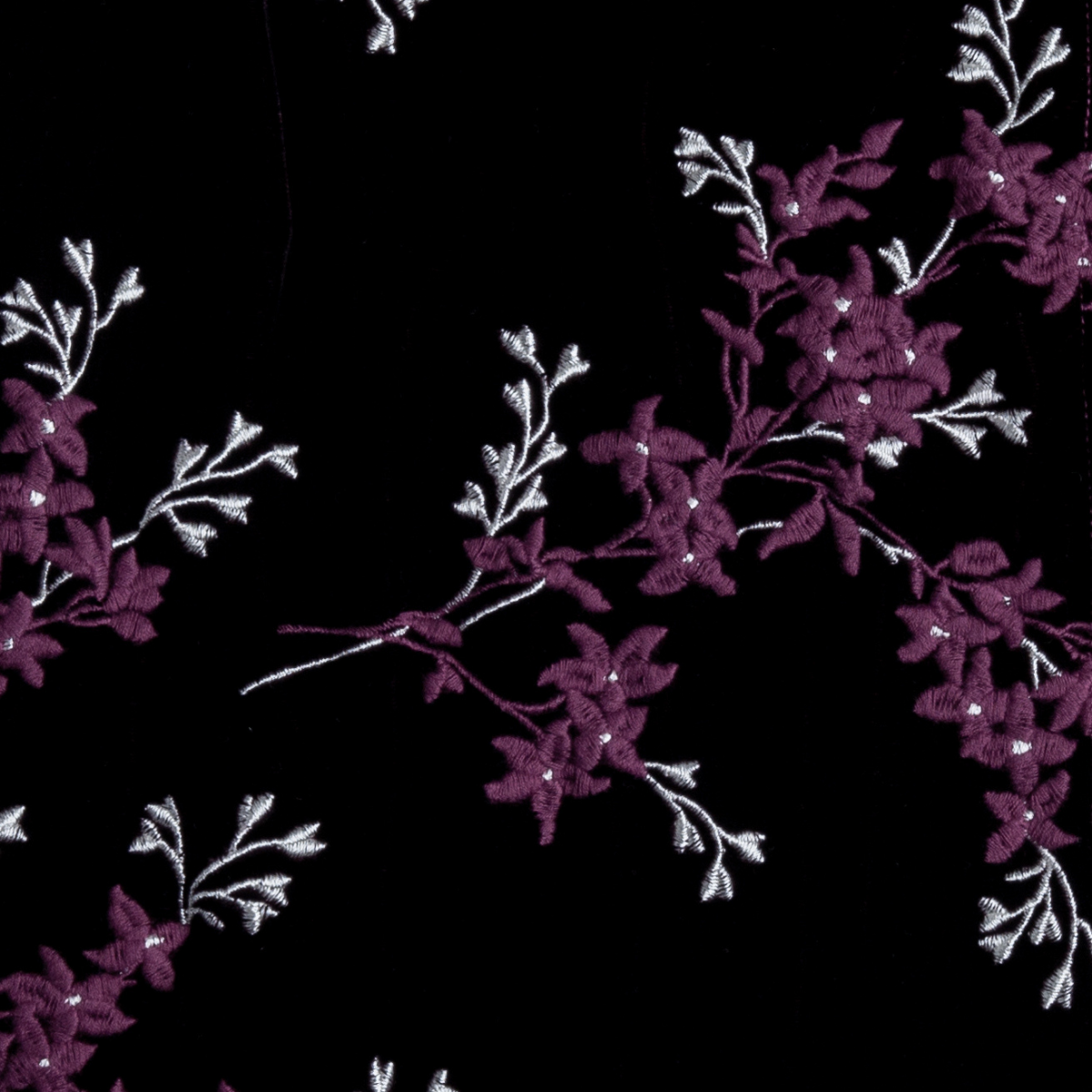 Fig: A close up of embroidered silk velvet fabric in fig, a richly saturated purple-garnet.