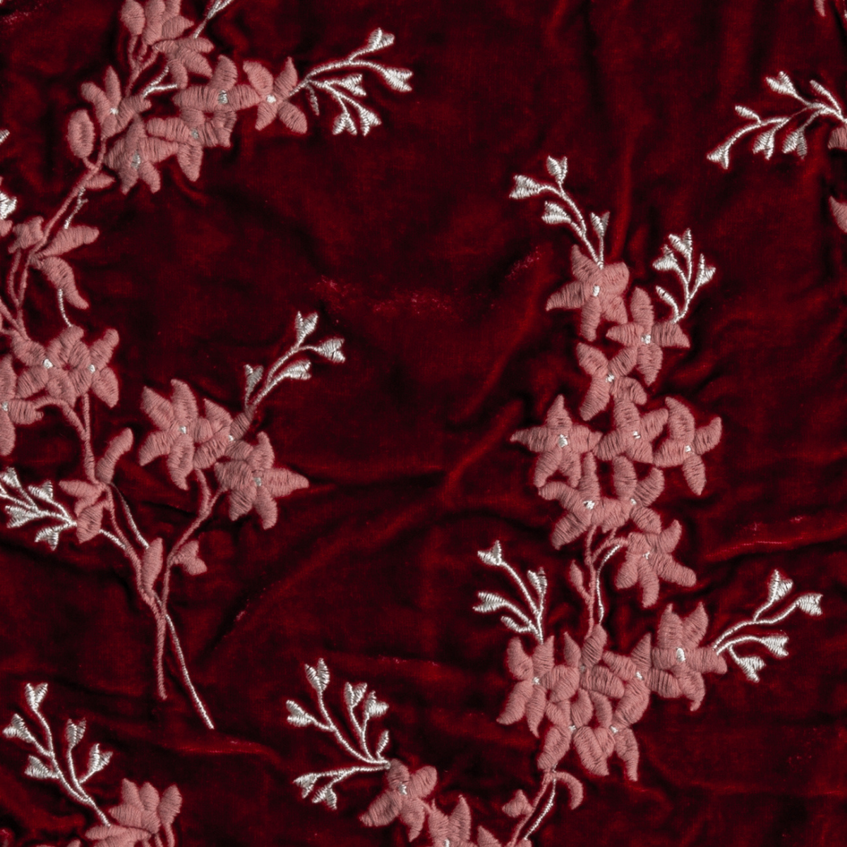 Poppy: A close up of embroidered silk velvet fabric in poppy, a warm coral pink.