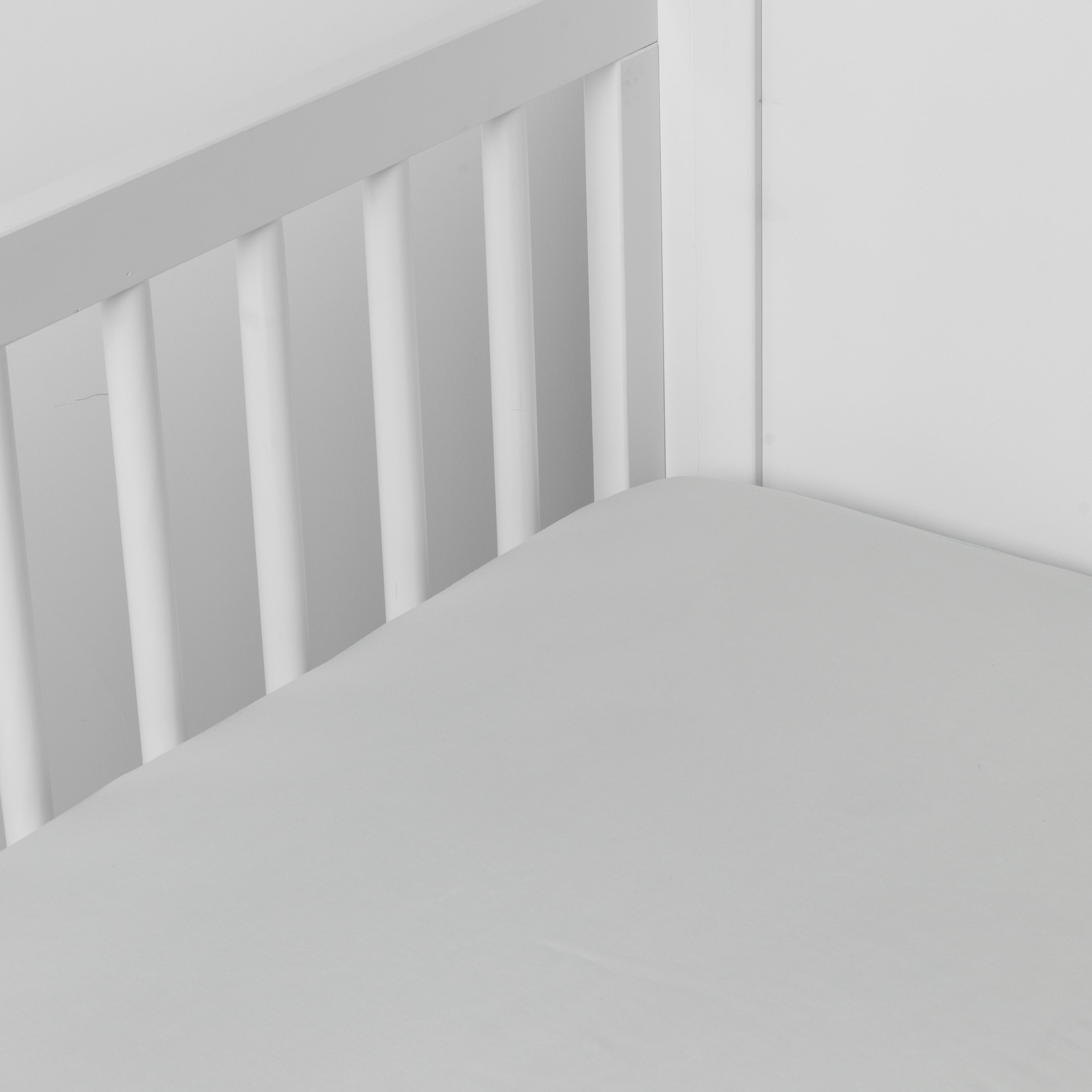 Cloud:  crib sheet shown on a mattress shown from overhead into the corner of a crib. 