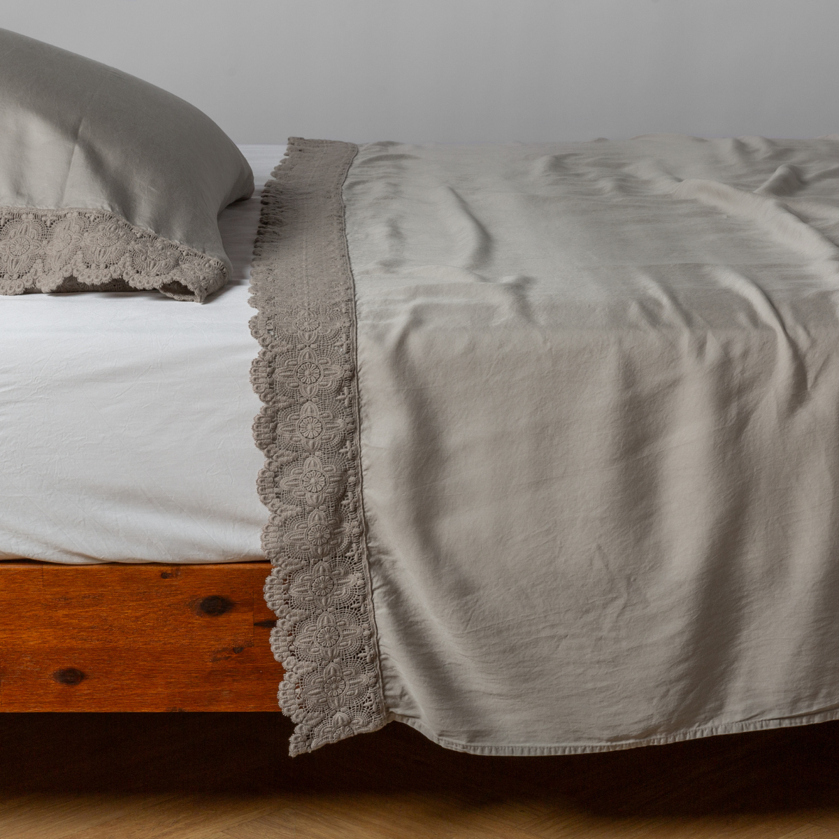 matching cotton lace trimmed flat sheet and pillowcase shown with simple white sheet - side view.