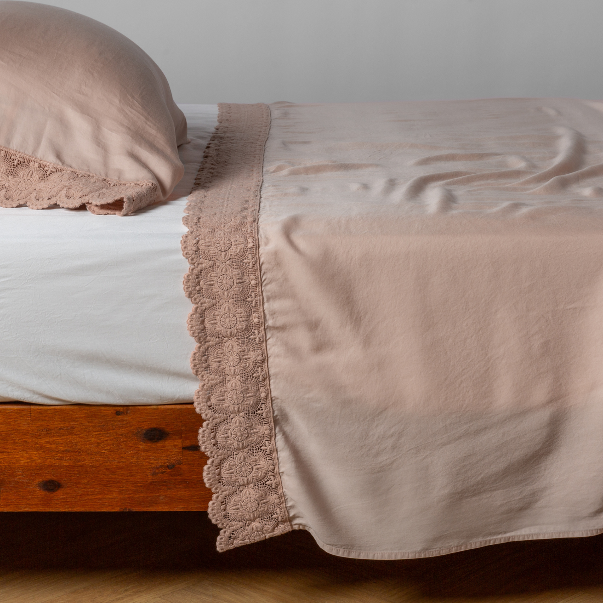 matching cotton lace trimmed flat sheet and pillowcase shown with simple white sheet - side view.