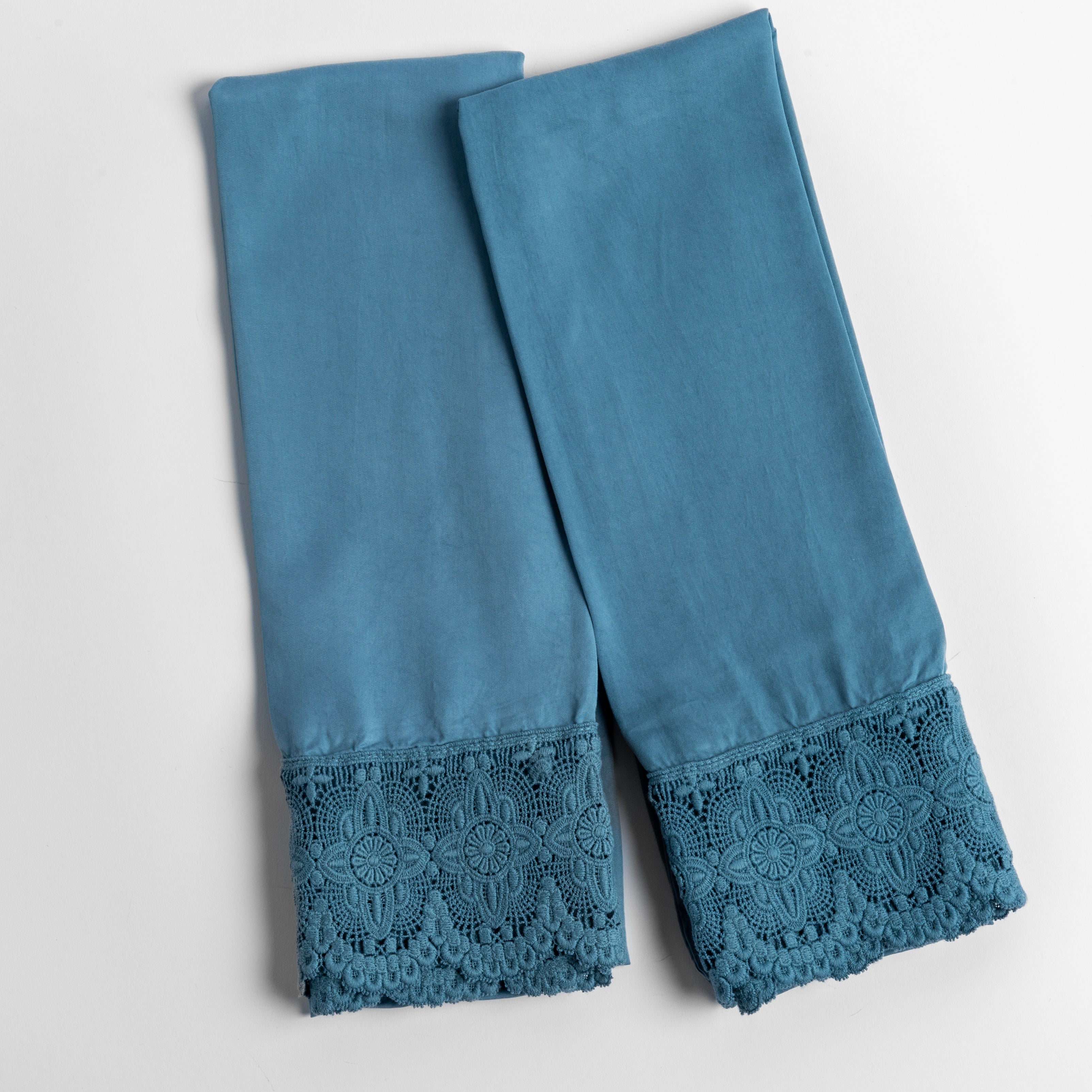 cotton lace trimmed tencel pillowcases folded and shot from overhead against a white background