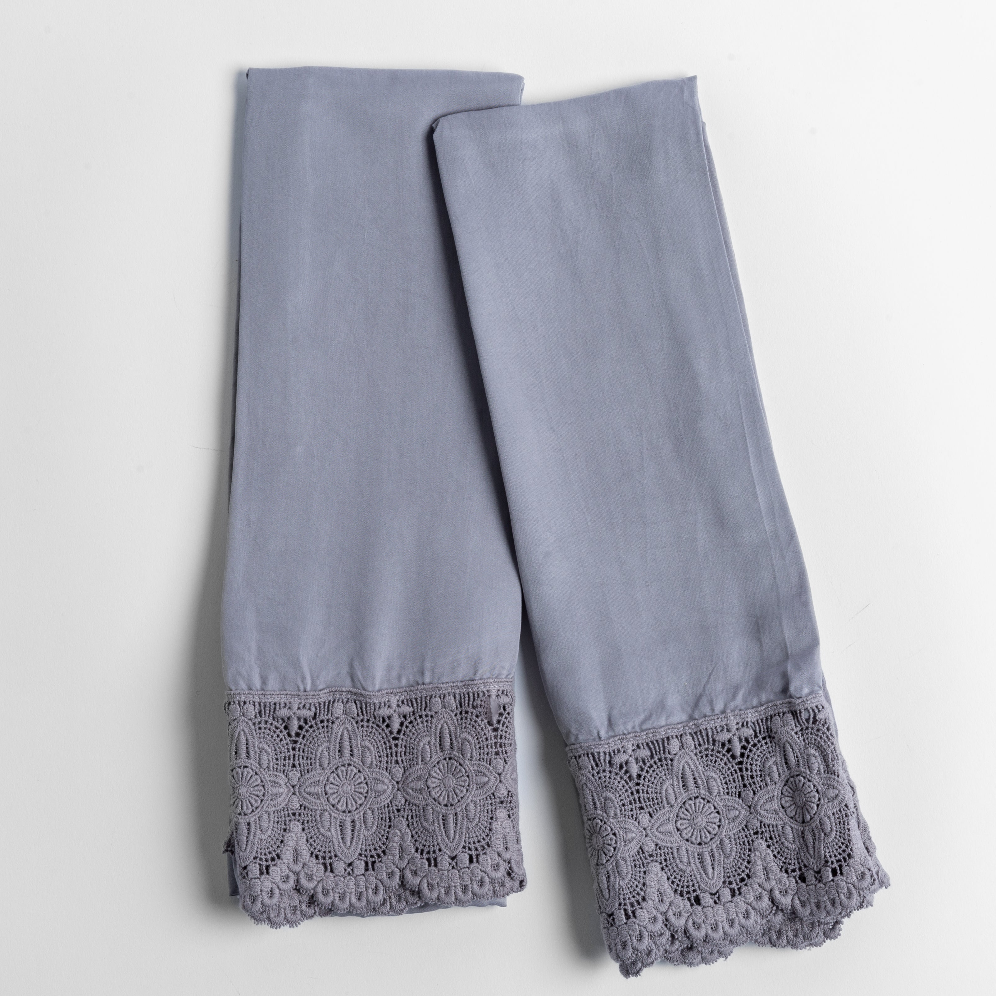 cotton lace trimmed tencel pillowcases folded and shot from overhead against a white background