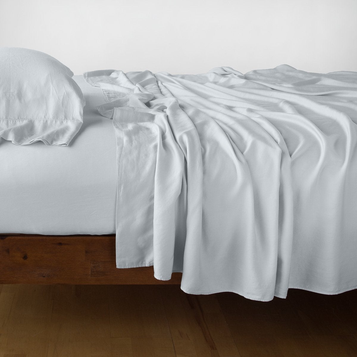 Cloud: fitted sheet with matching rumpled flat sheet and sleeping pillow - side view.