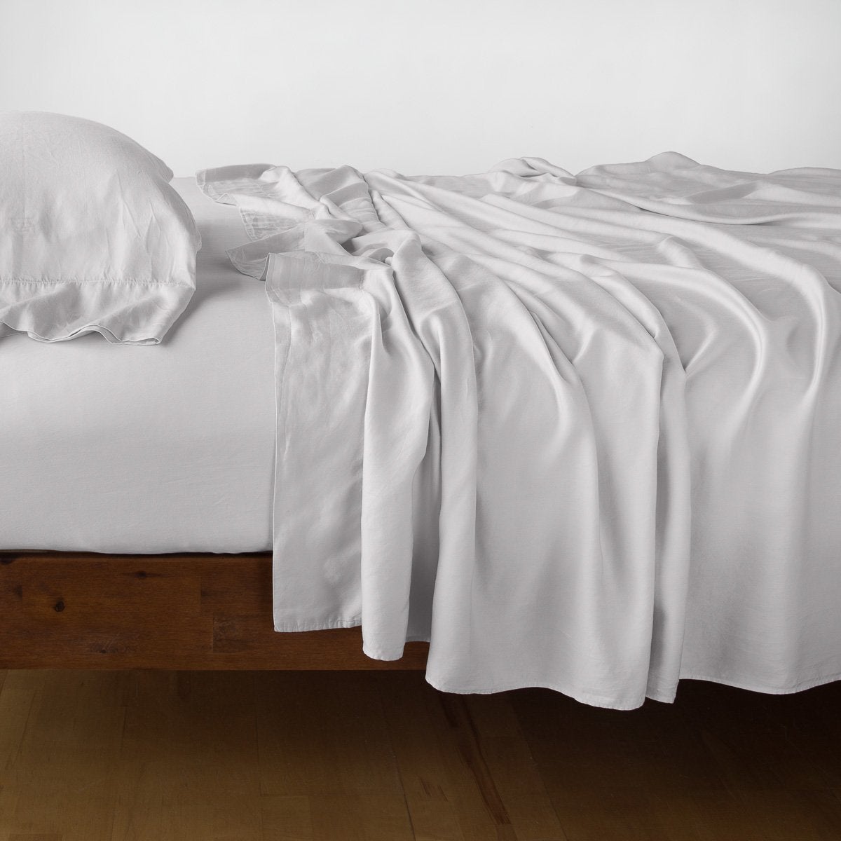 Sterling: fitted sheet with matching rumpled flat sheet and sleeping pillow - side view.