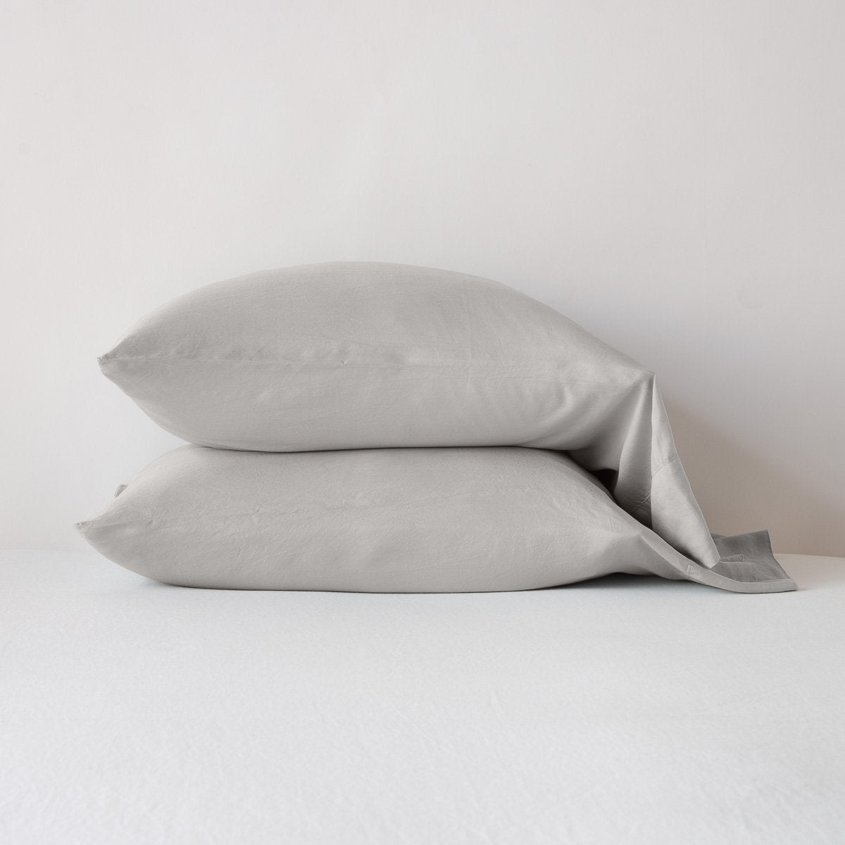 Fog: sleeping pillows stacked neatly against a white backdrop - side view.