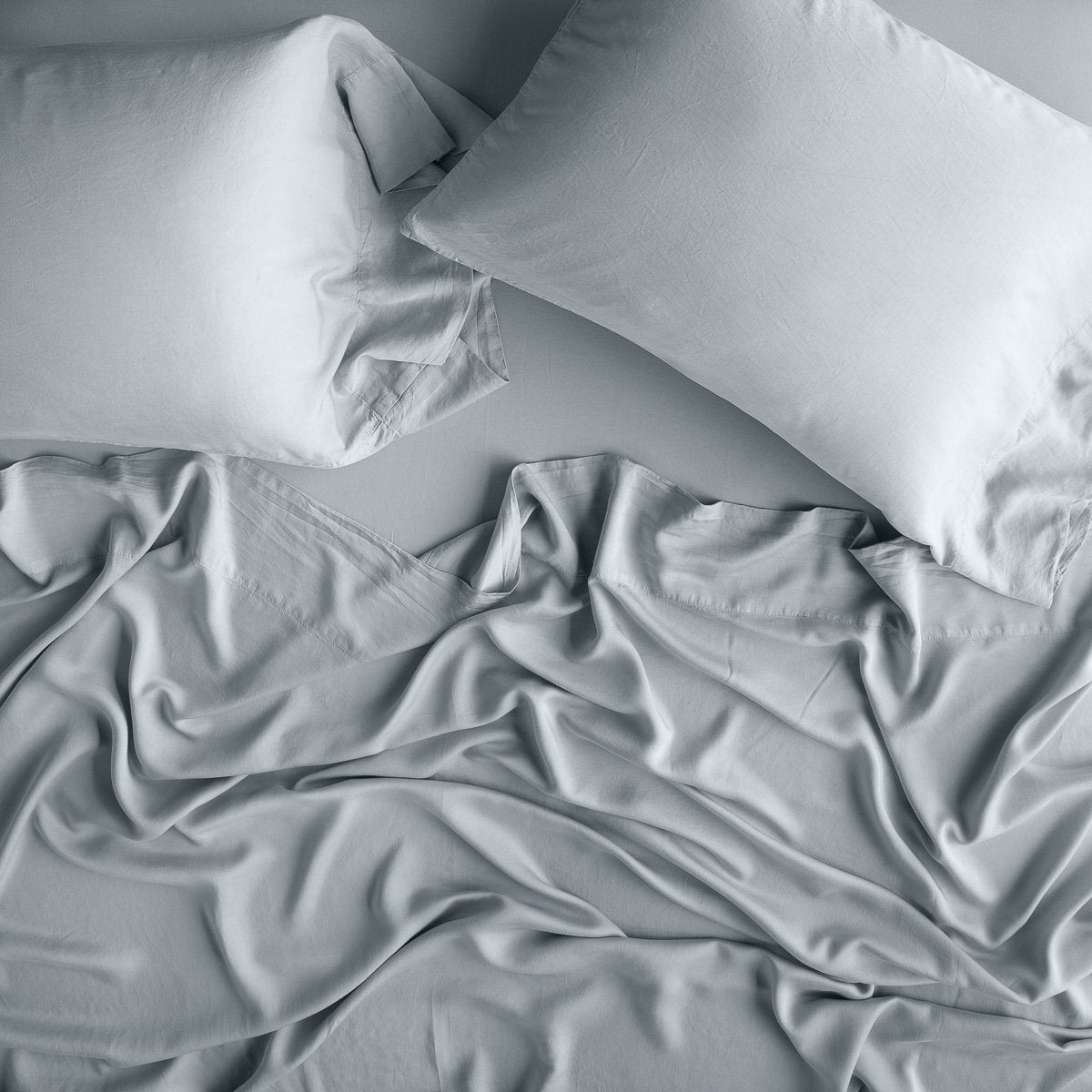 Mineral: sleeping pillows laid flat over rumpled matching sheeting - overhead view.