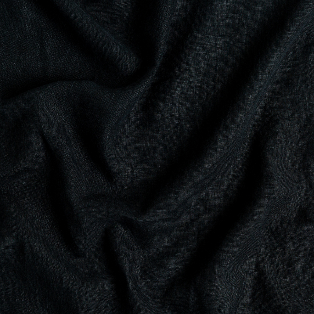 Corvino: A close up of midweight linen fabric in Corvino, a black tone.