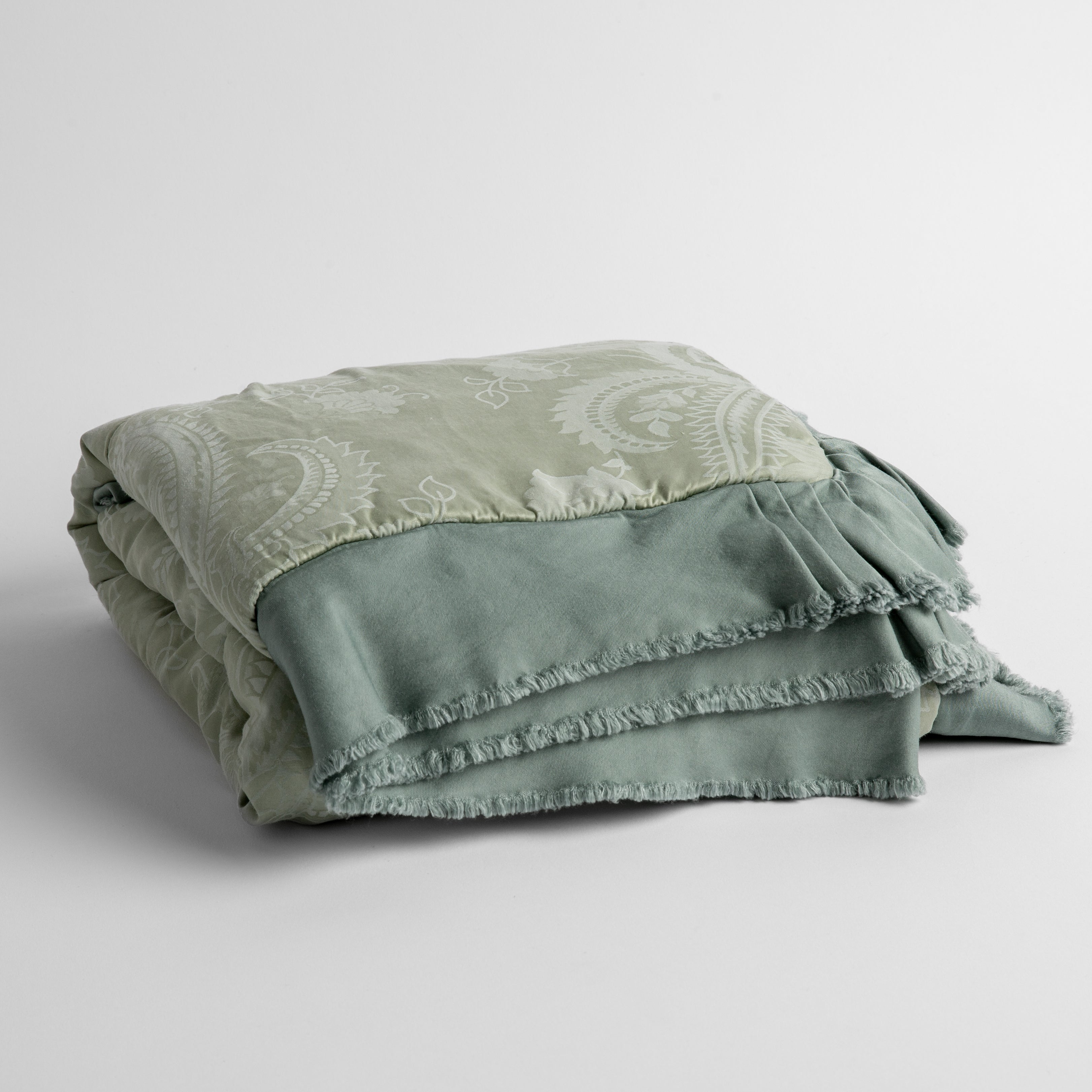 Eucalyptus: a silk and tencel™ jacquard baby blanket folded and shot against a white background with the ruffled trim situated to be visible