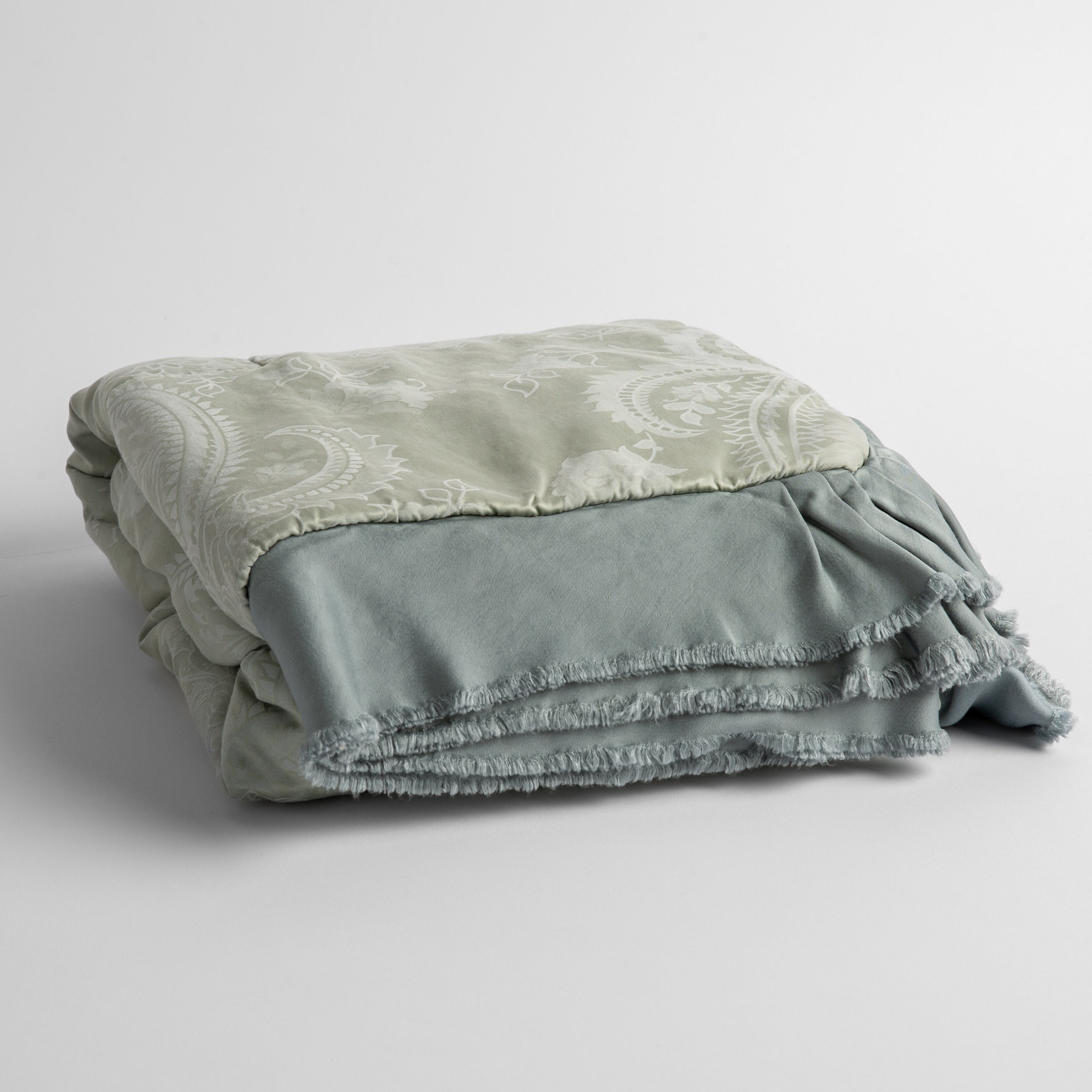 Mineral:  silk and tencel™ blend jacquard baby blanket folded and shot from a slight overhead angle to show the trim detail against a white background.