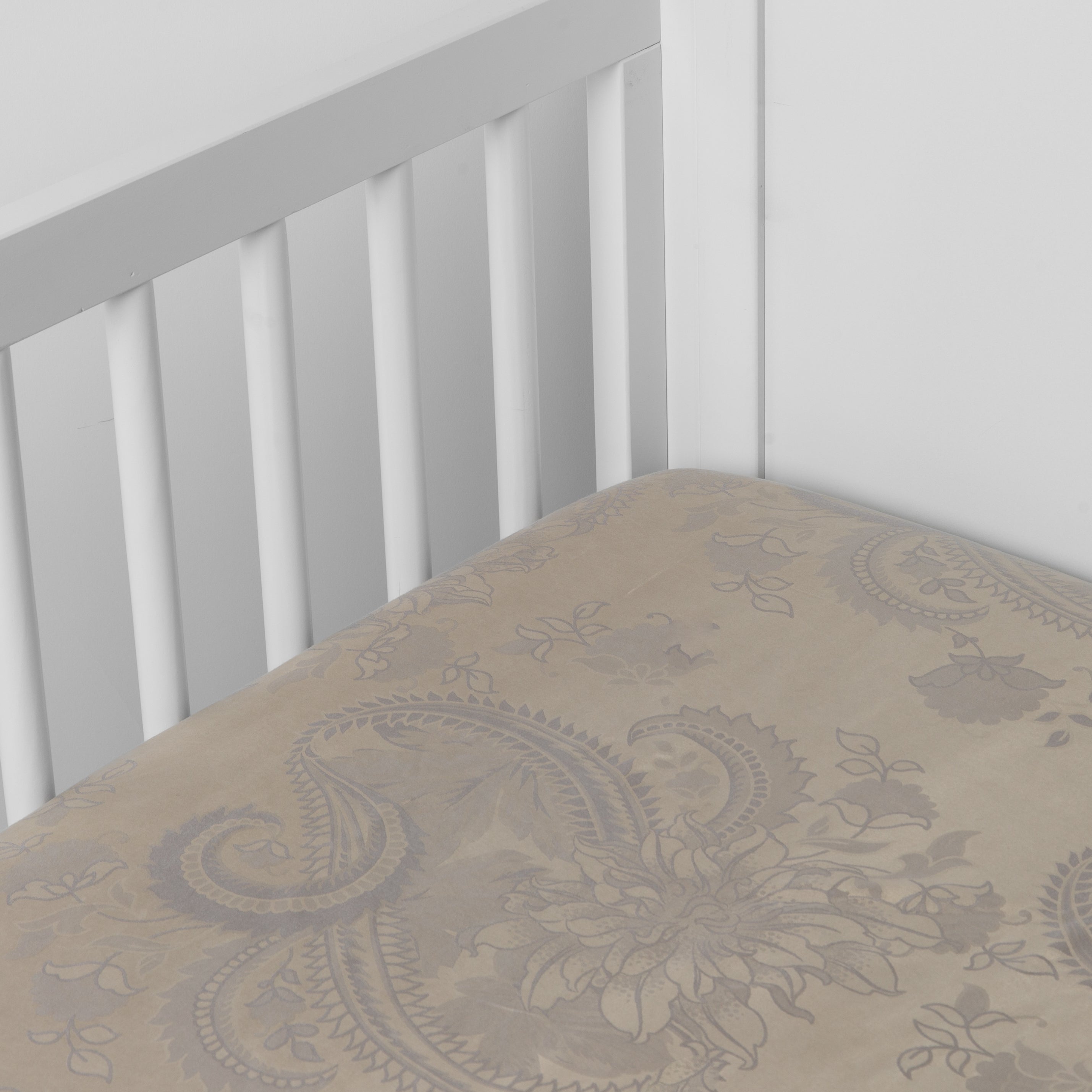 Moonlight: silk and tencel™ blend jacquard crib sheet shot from above at a slight angle into the corner of a white crib. 