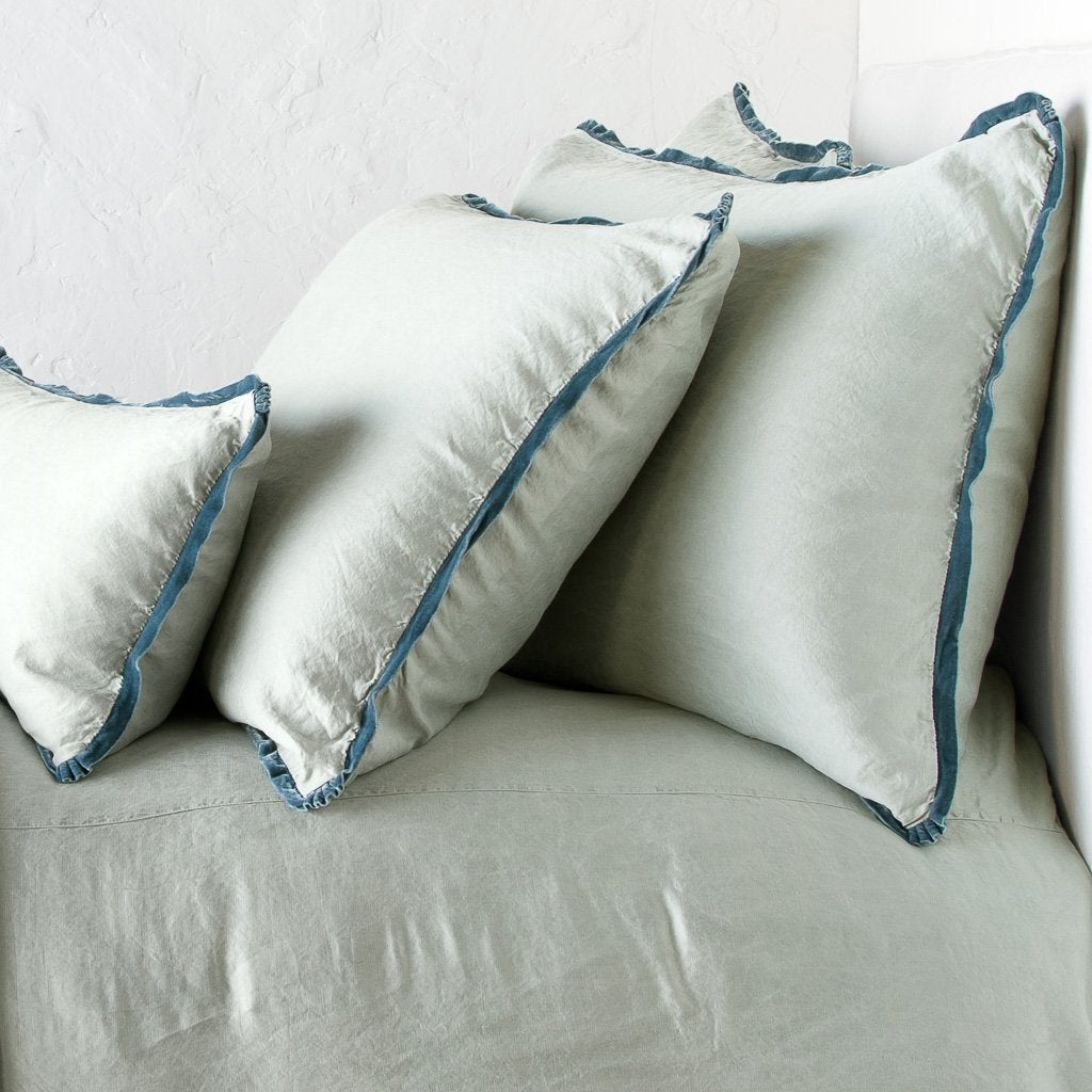 : Paloma shams and lumbar pillow on a matching duvet cover - eucalyptus, cropped side view.