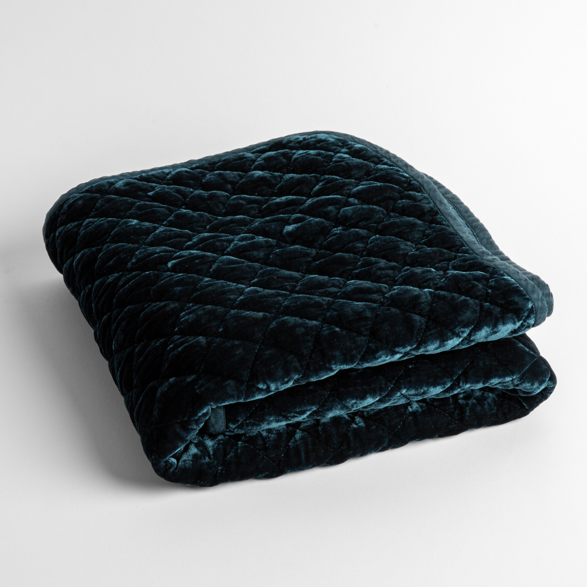 Midnight:  a folded quilted silk velvet baby blanket shown from overhead to showcase quilting  pattern and texture. 