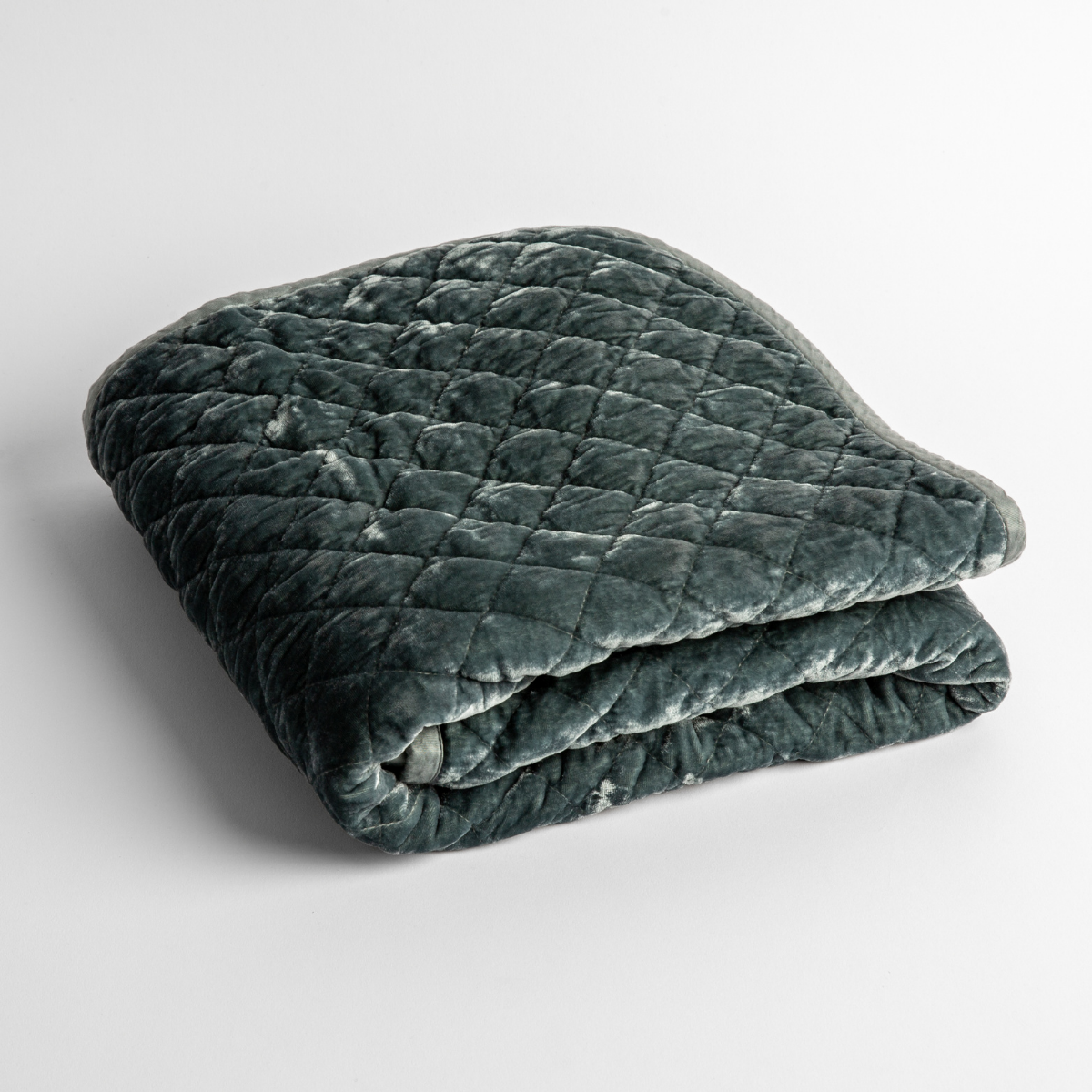 Mineral:   a folded quilted silk velvet baby blanket shown from overhead to showcase quilting  pattern and texture. 