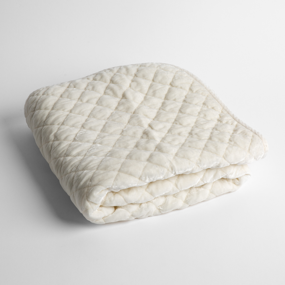 Winter White: a folded quilted silk velvet baby blanket shown from overhead to showcase quilting  pattern and texture. 