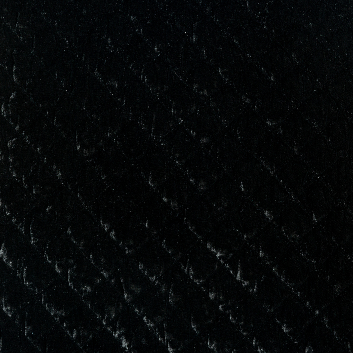 Corvino: A close up of quilted silk velvet fabric in Corvino, a black tone.