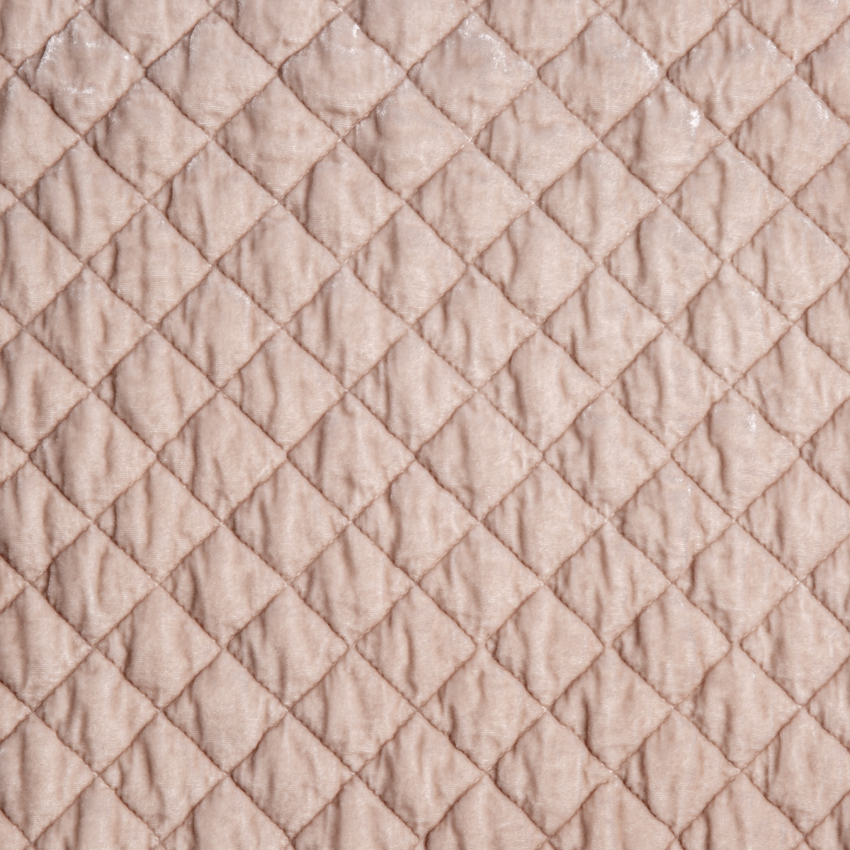 Pearl: A close up of quilted silk velvet fabric in pearl, a nude-like, soft rose pink tone.