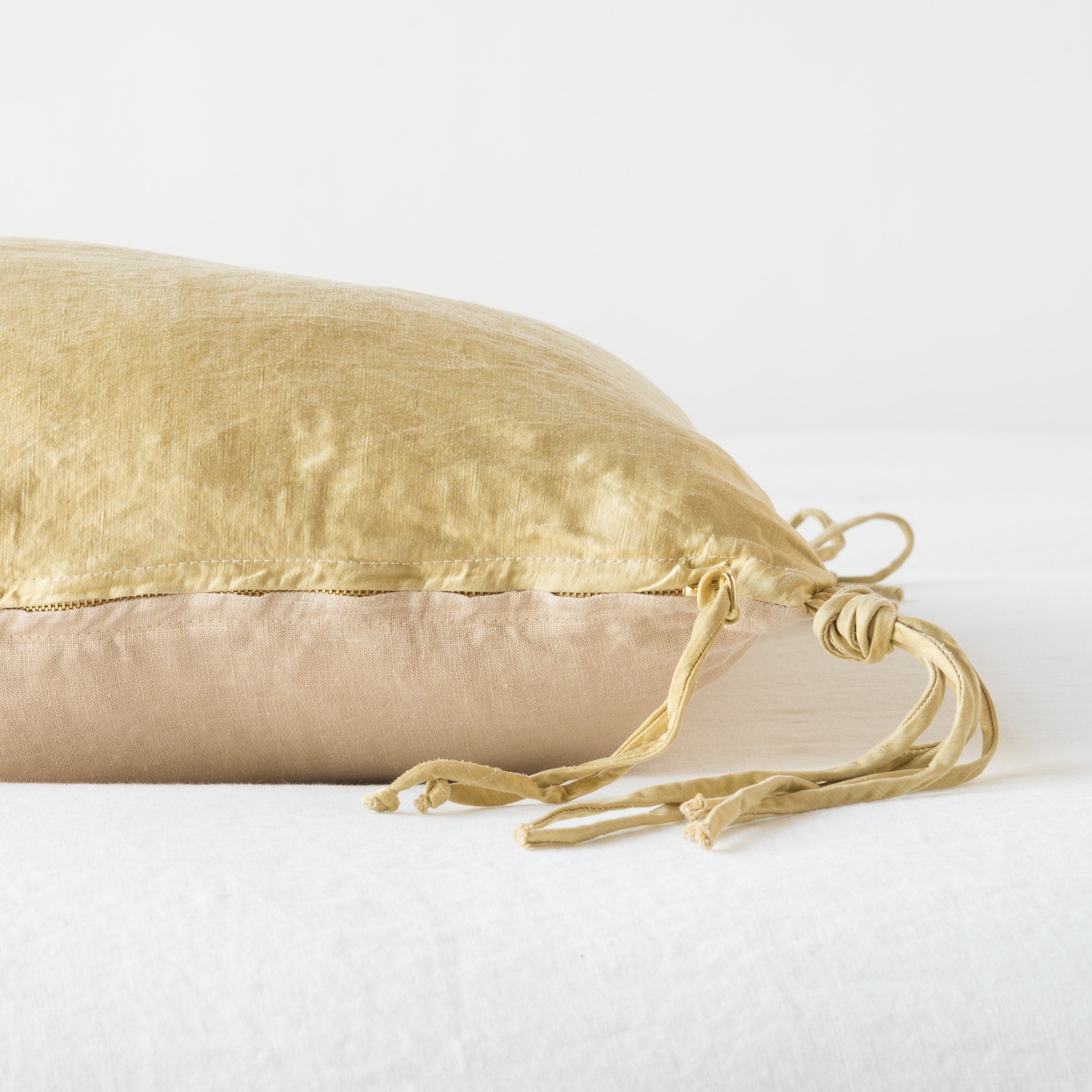 : Close-up side vew of Taline throw pillow featuring brass zipper with charmeuse pull and linen back - honeycomb.