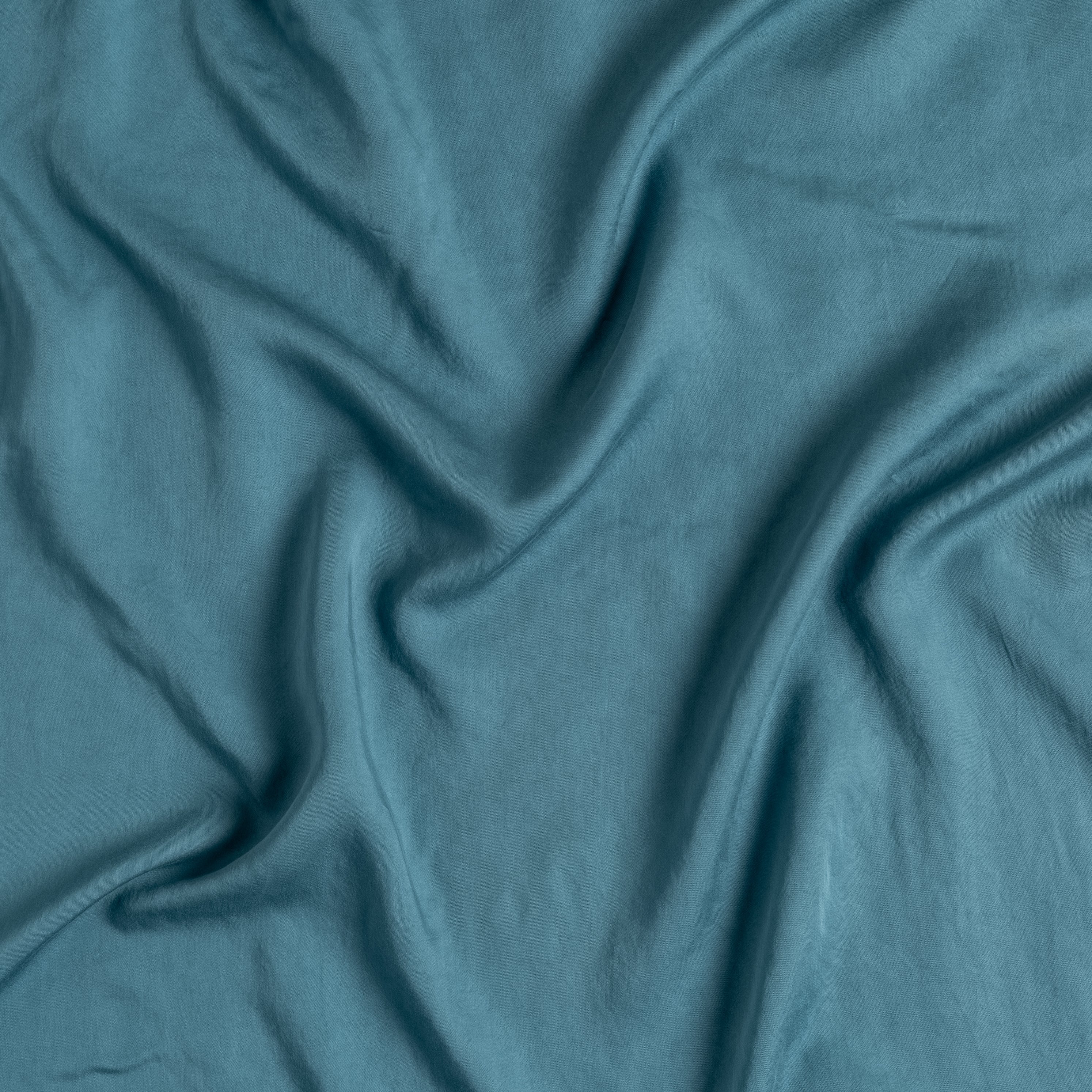 Cenote: A close up of Tencel™ fabric in cenote, a vibrant, ocean-inspired blue-green.
