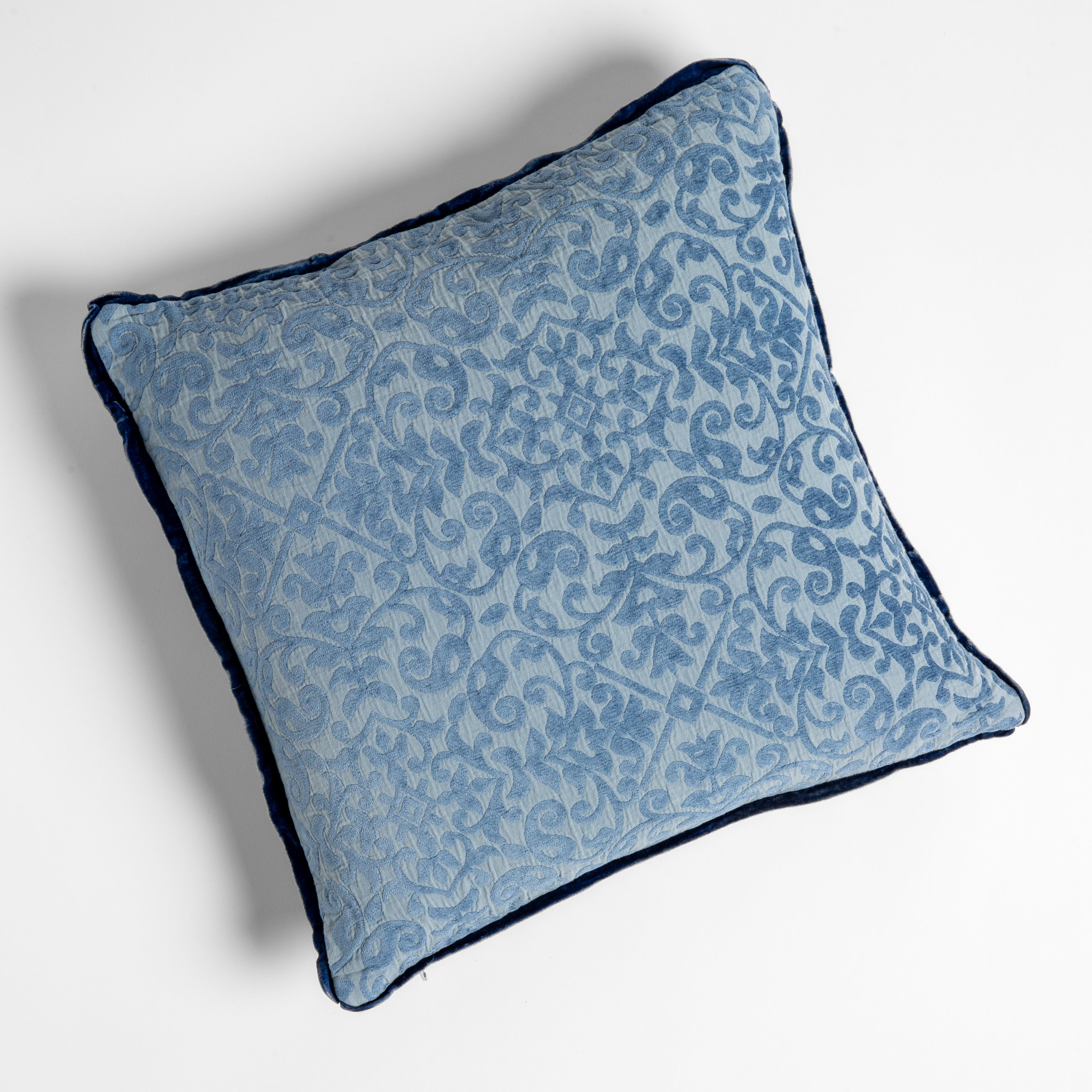 Tahoe Blue: Organic cotton damask square pillow with silk velvet trim on white background — overhead angle.