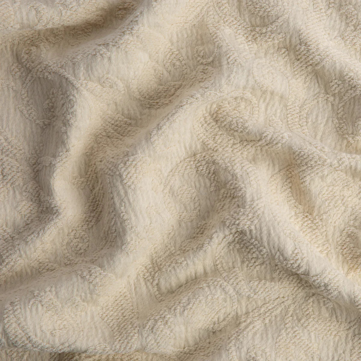 Parchment: A close up of Adele fabric in parchment, a warm, antiqued cream. The fabric is rumpled to show the cotton damask texture.