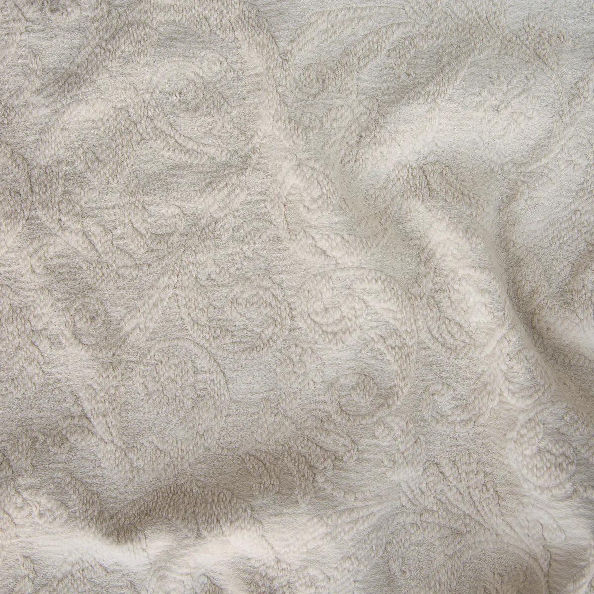 Parchment: A close up of Adele fabric in parchment, a warm, antiqued cream. The fabric is rumpled to show the cotton damask texture.