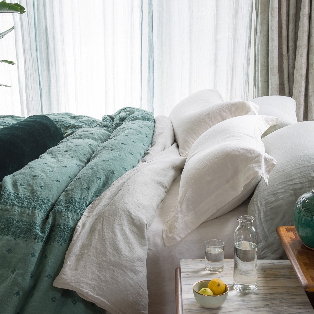 [allvariants]: Linen shams in white and matching sheeting, mixed with other textures of embroidered linen and silk velvet in jade - side view. 