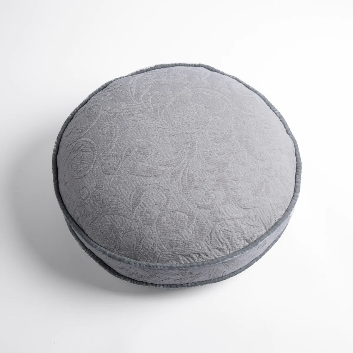 Sterling: Organic cotton damask round pillow with silk velvet trim on white background — overhead angle.