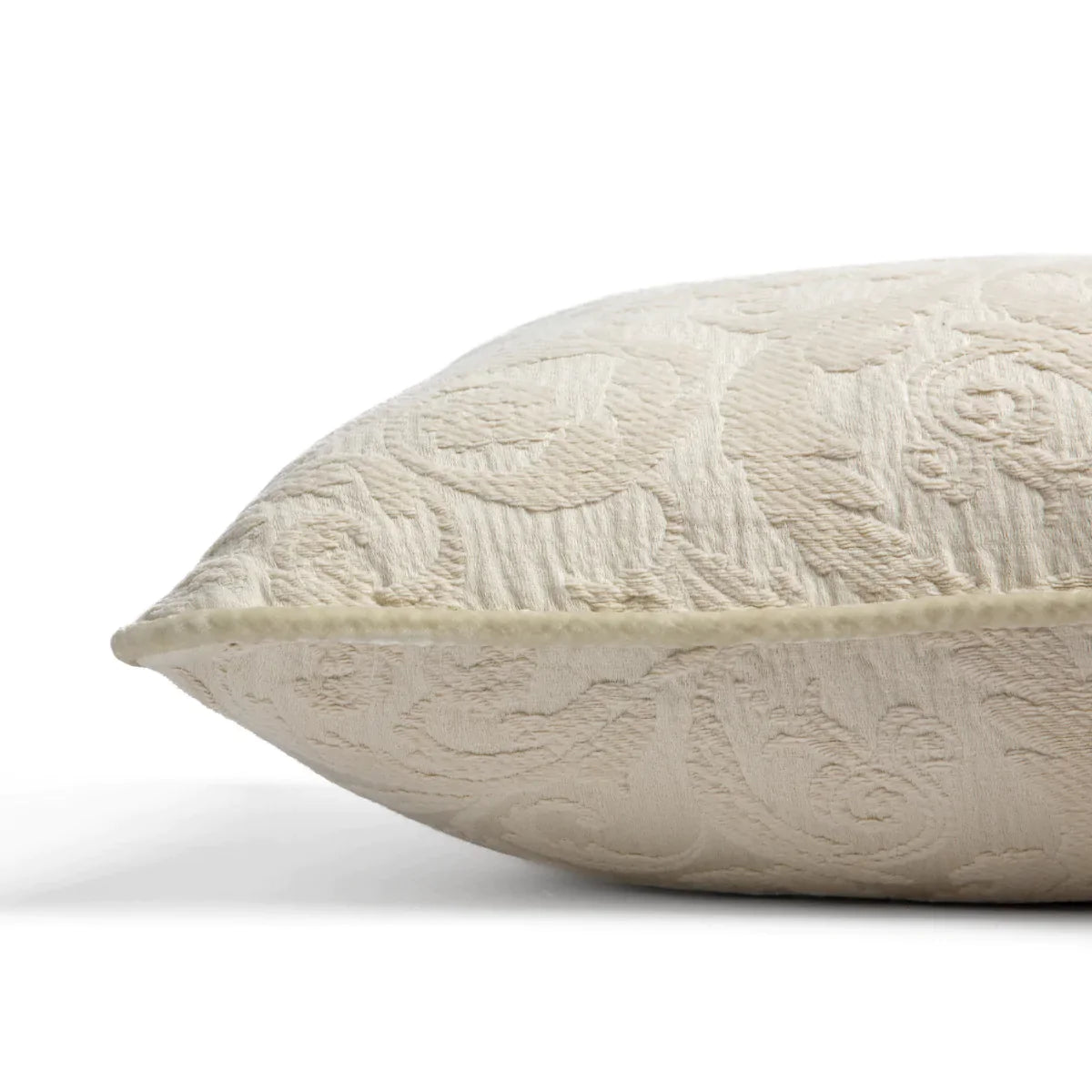 Parchment: Organic cotton damask square pillow with silk velvet trim on white background — side angle.