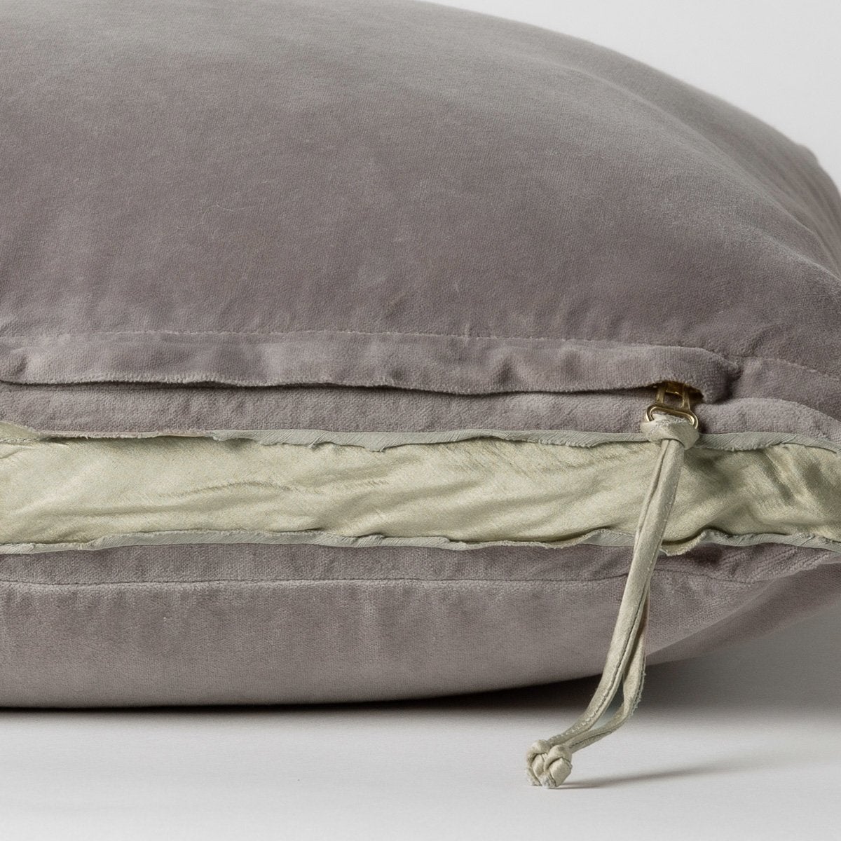 Fog: Close-up of charmeuse gusset, raw-edge trim, and brass zipper detail  on cotton velvet sham - side view.