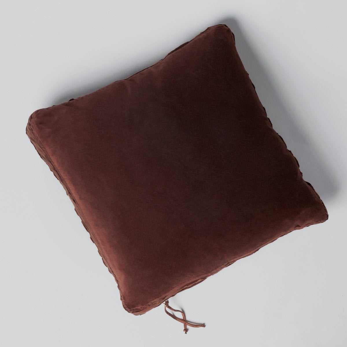 Mahogany: Cotton velvet 24 by 24 pillow on a plain background - overhead view.