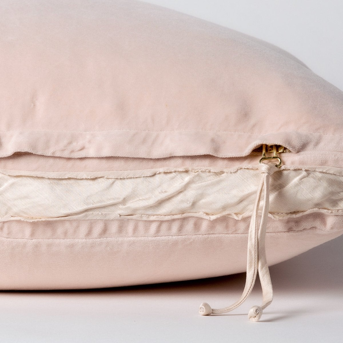 Pearl: Close-up of charmeuse gusset, raw-edge trim, and brass zipper detail  on cotton velvet sham - side view.