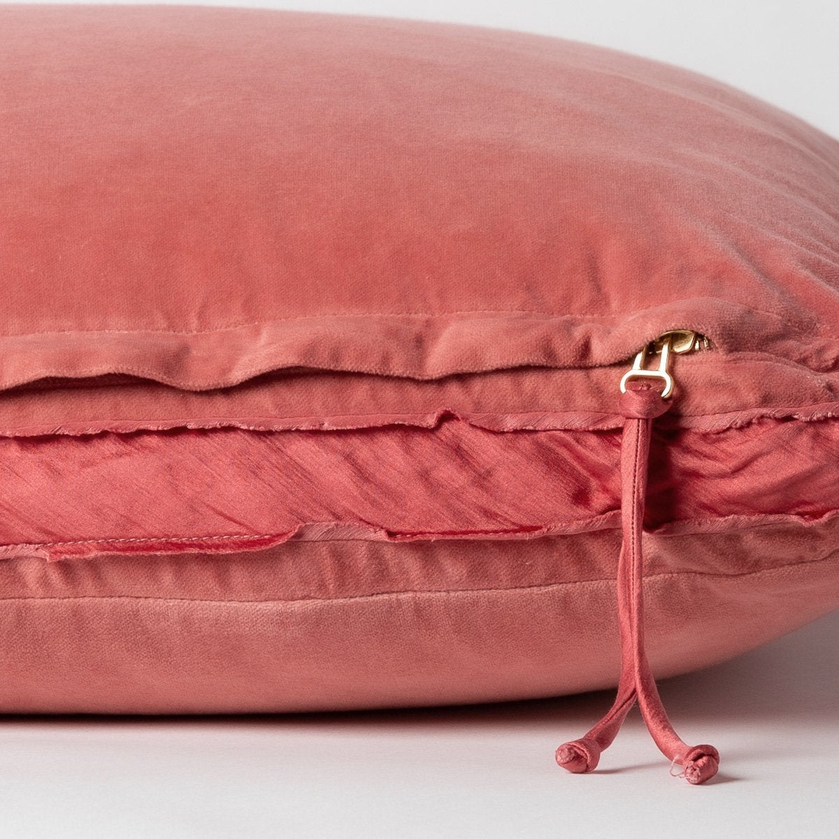 Poppy: Close-up of charmeuse gusset, raw-edge trim, and brass zipper detail on Harlow pillow - side view.