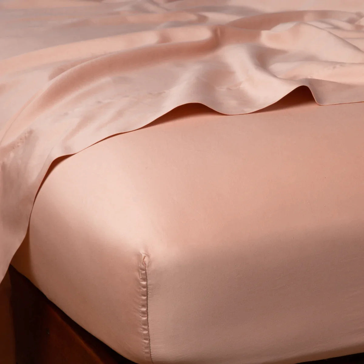 Rouge: Cotton sateen fitted sheet shown from the top corner, highlighting the shine of the fabric.
