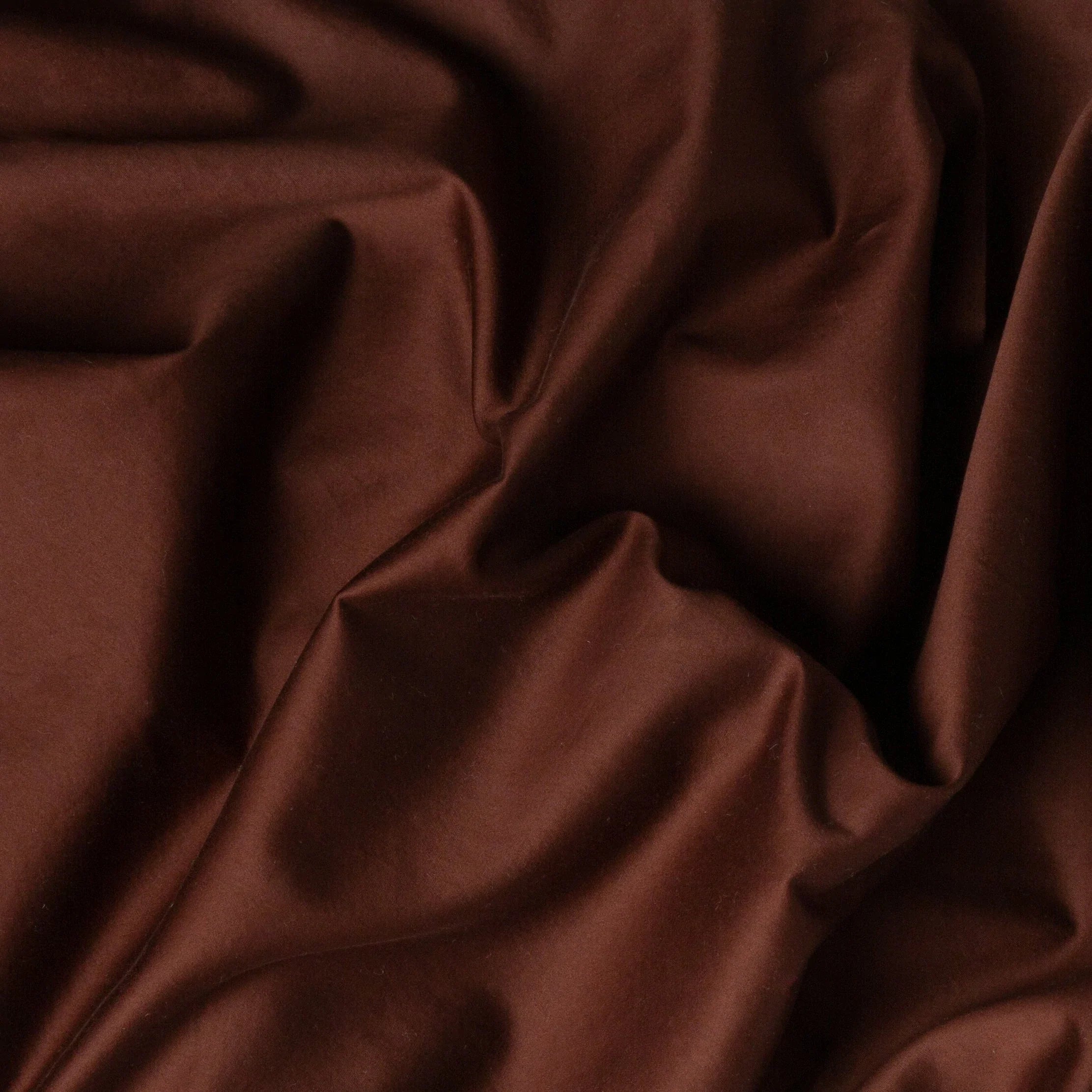 Mahogany: A close up of cotton sateen fabric in mahogany, a deep, earthen, reddish brown. 