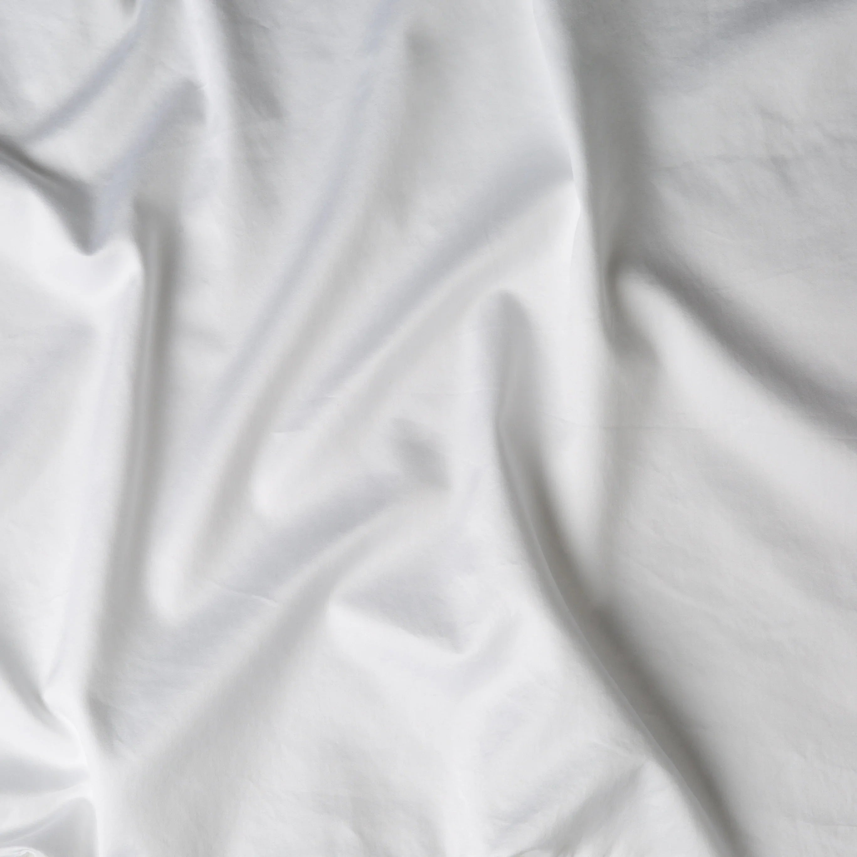 White: A close up of cotton sateen fabric in white. 